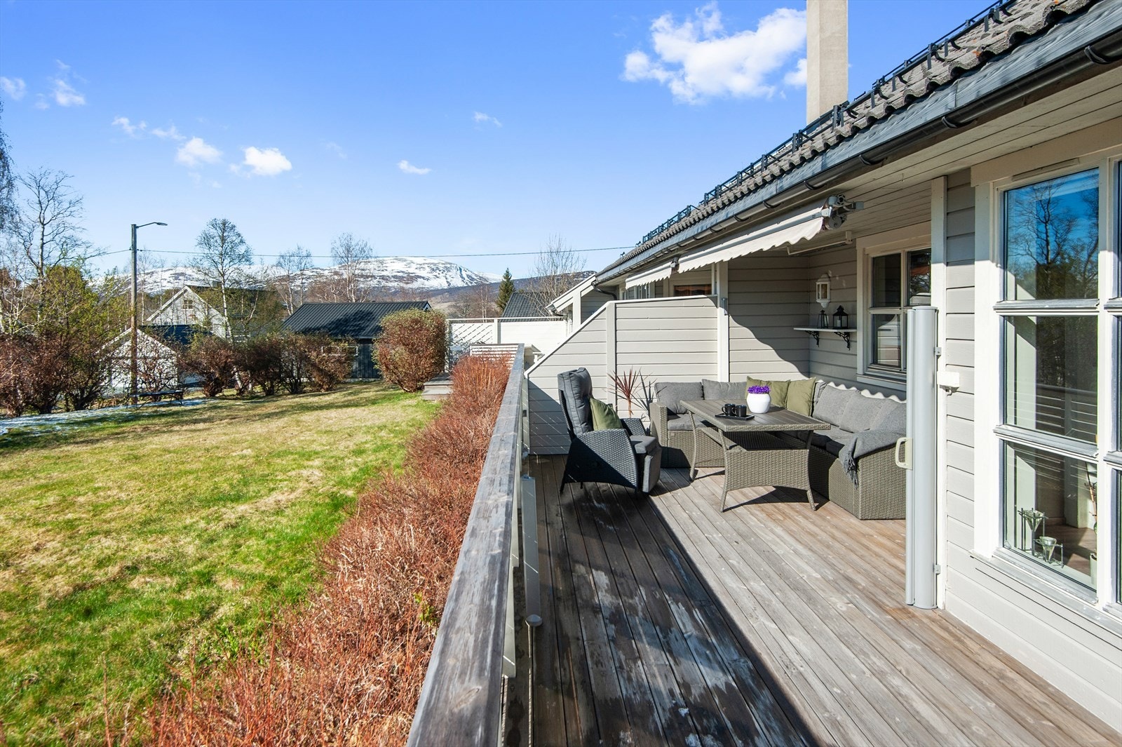 Delvis takoverbygd terrasse med levegger, markise og terrassevarmer Galleribilde