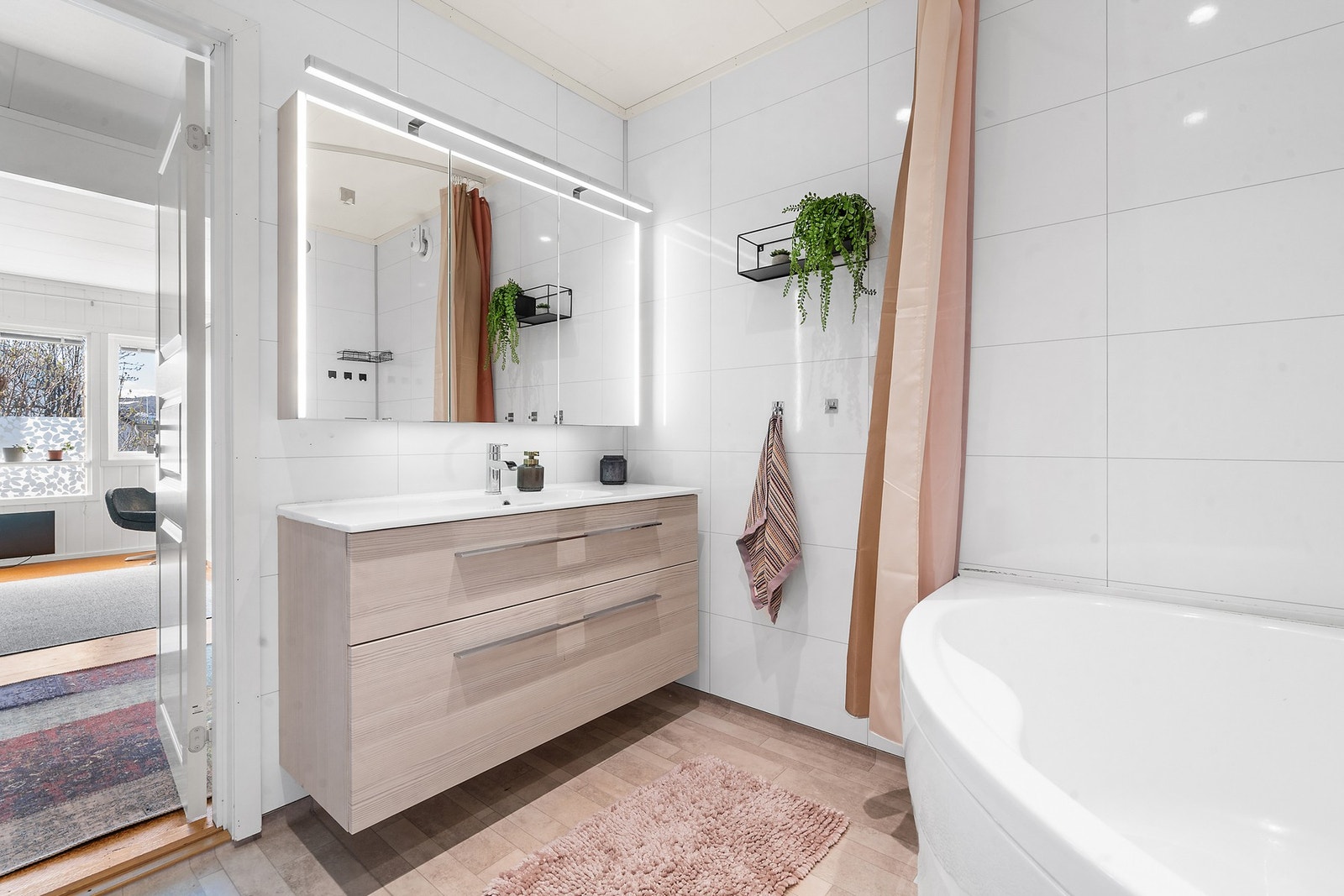 Badet i første etasje har en moderne innredning med heldekkende servant og speil med integrert belysning. Galleribilde