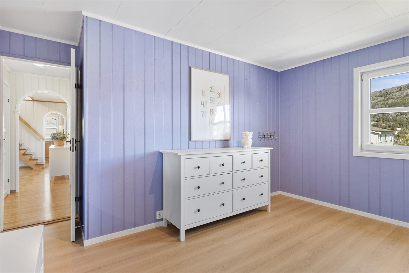 Soverom med laminat på gulvet og malte panelplater. Galleribilde