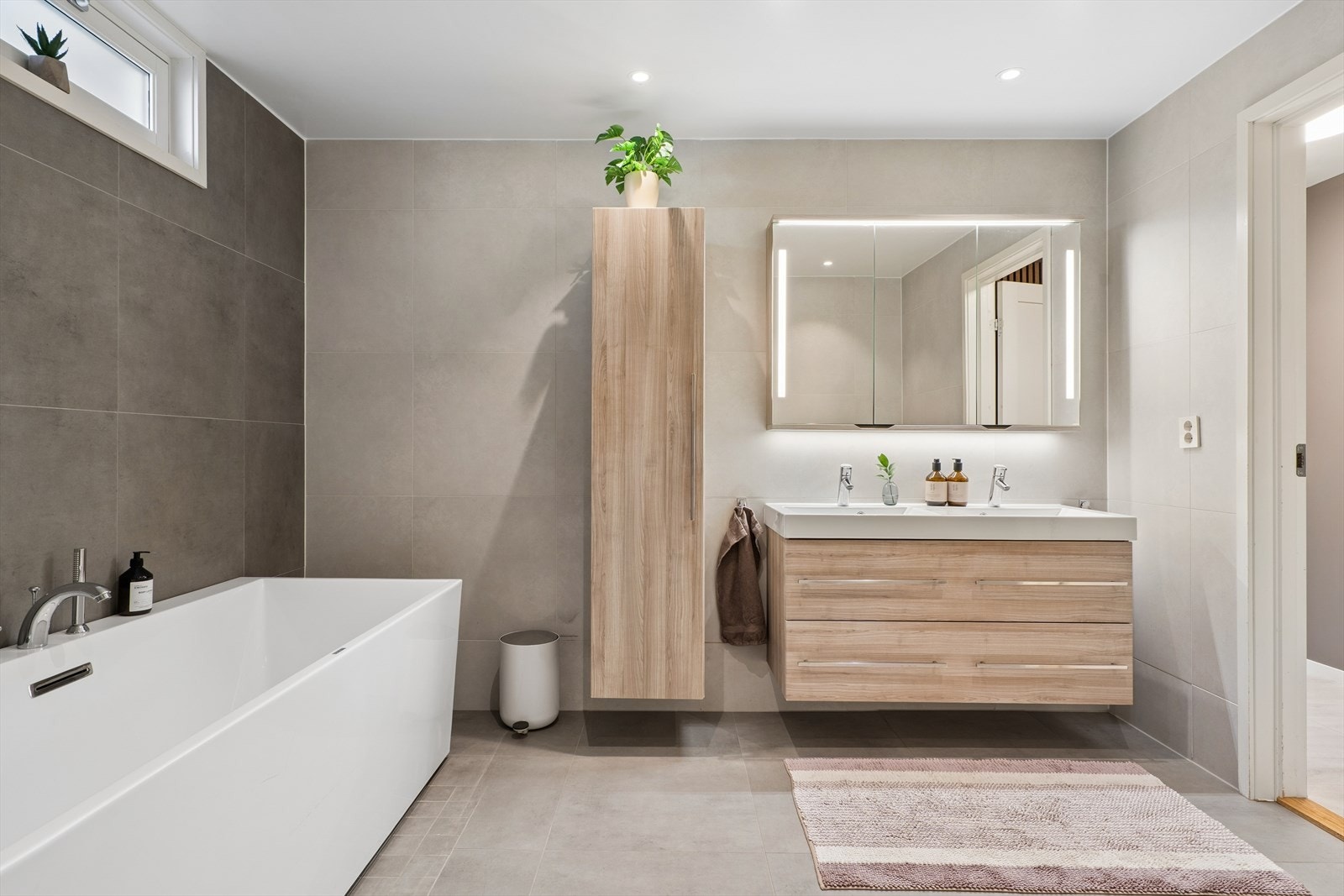 Badet er utstyrt med både badekar og dusjhjørne, og har elektriske varmekabler i gulvet. Galleribilde