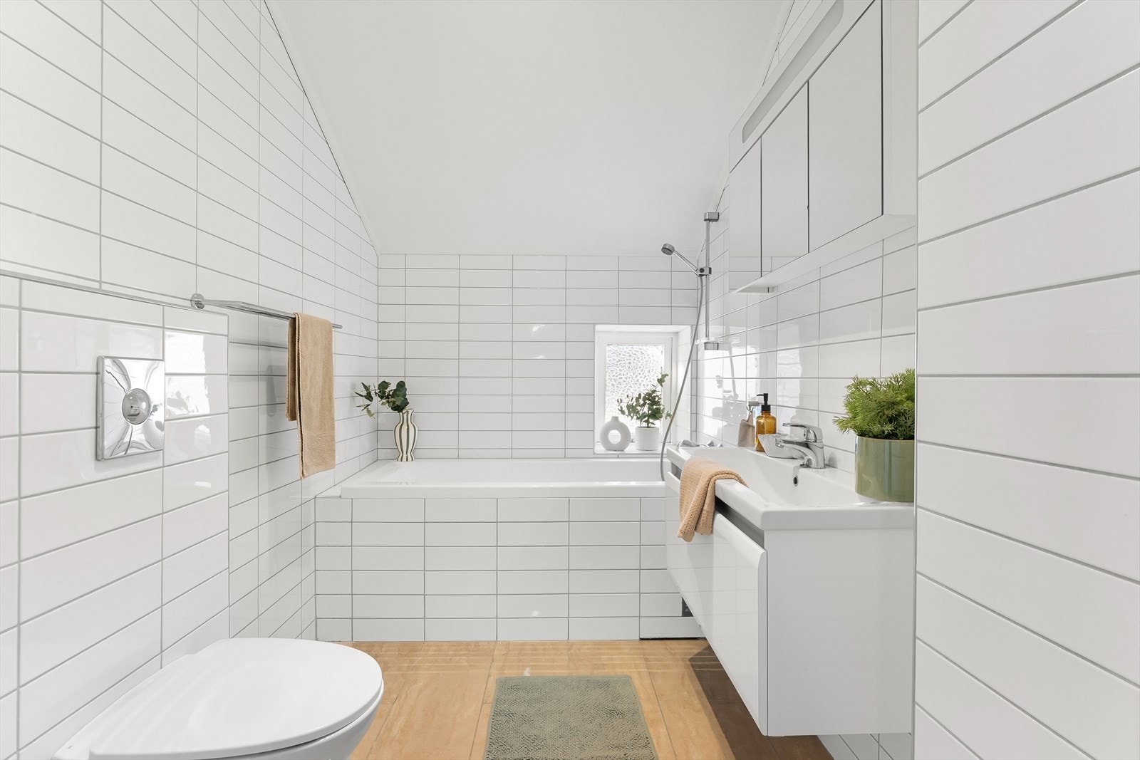 Bad 2 med inngang ved hovedsoverom består av innebygget badekar, vegghengt toalett og 80 cm servant med underskuff. Galleribilde