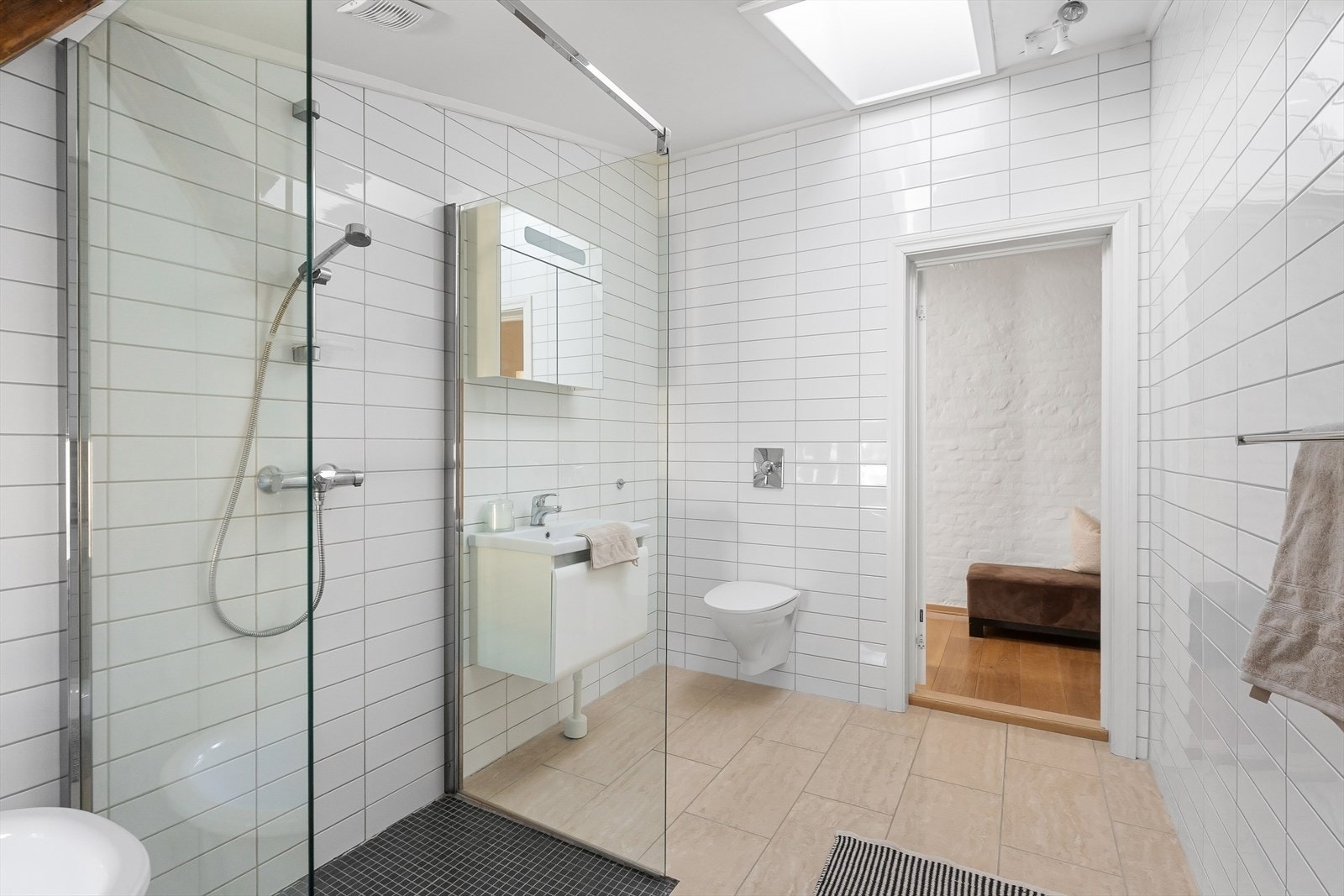 Bad 1 med inngang fra entré har flislagte vegger og gulv med varmekabler, overlys i himling og er av god størrelse. Galleribilde