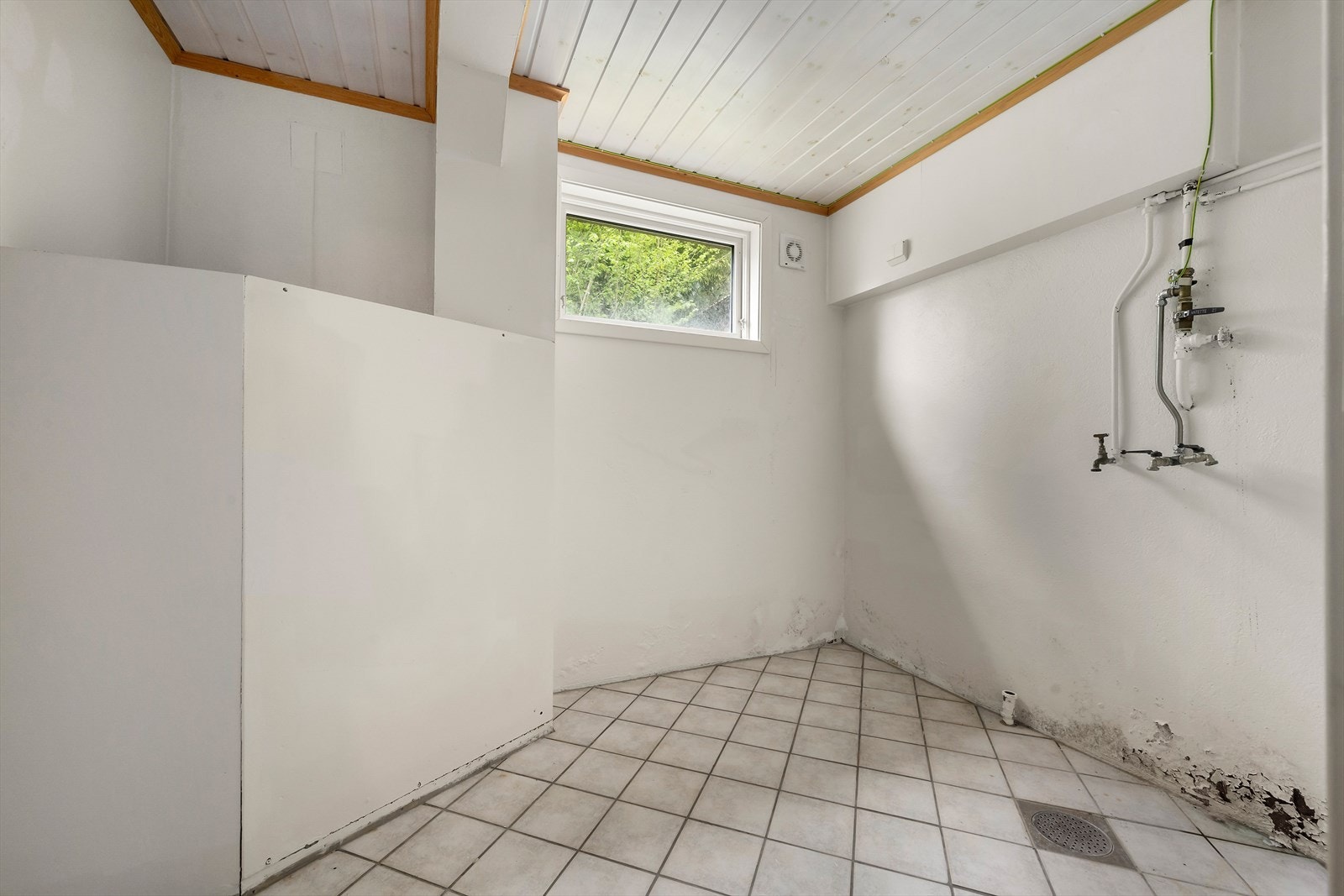 Vaskerom i underetasjen med flislagt golv. Galleribilde