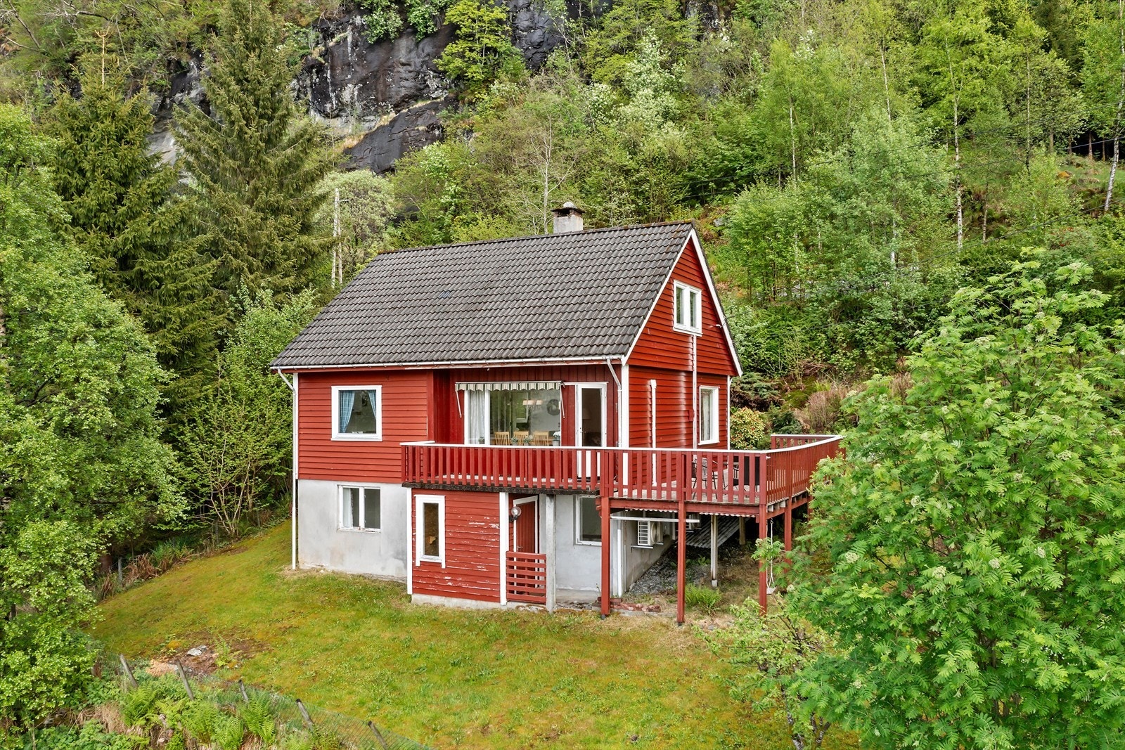 Fasaden er kledd i malt trepanel, og taket har takstein frå byggeåret. Galleribilde