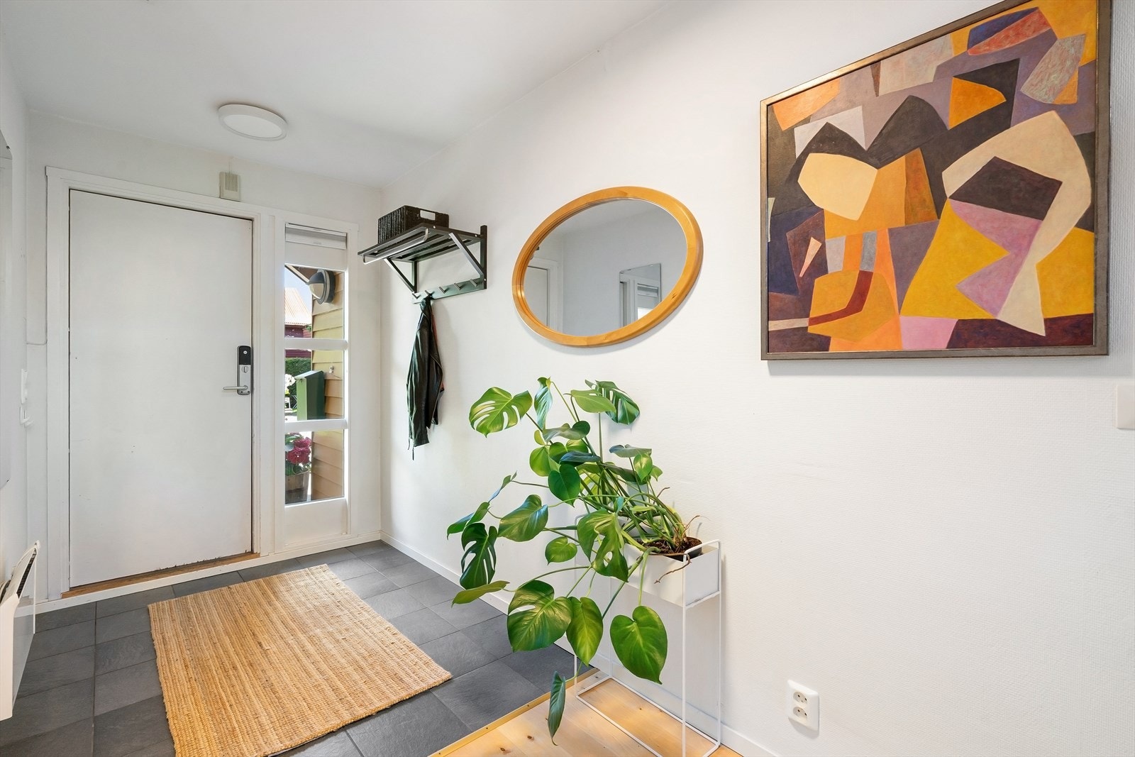 Lys og innbydende entré med flislagt gulv. Galleribilde