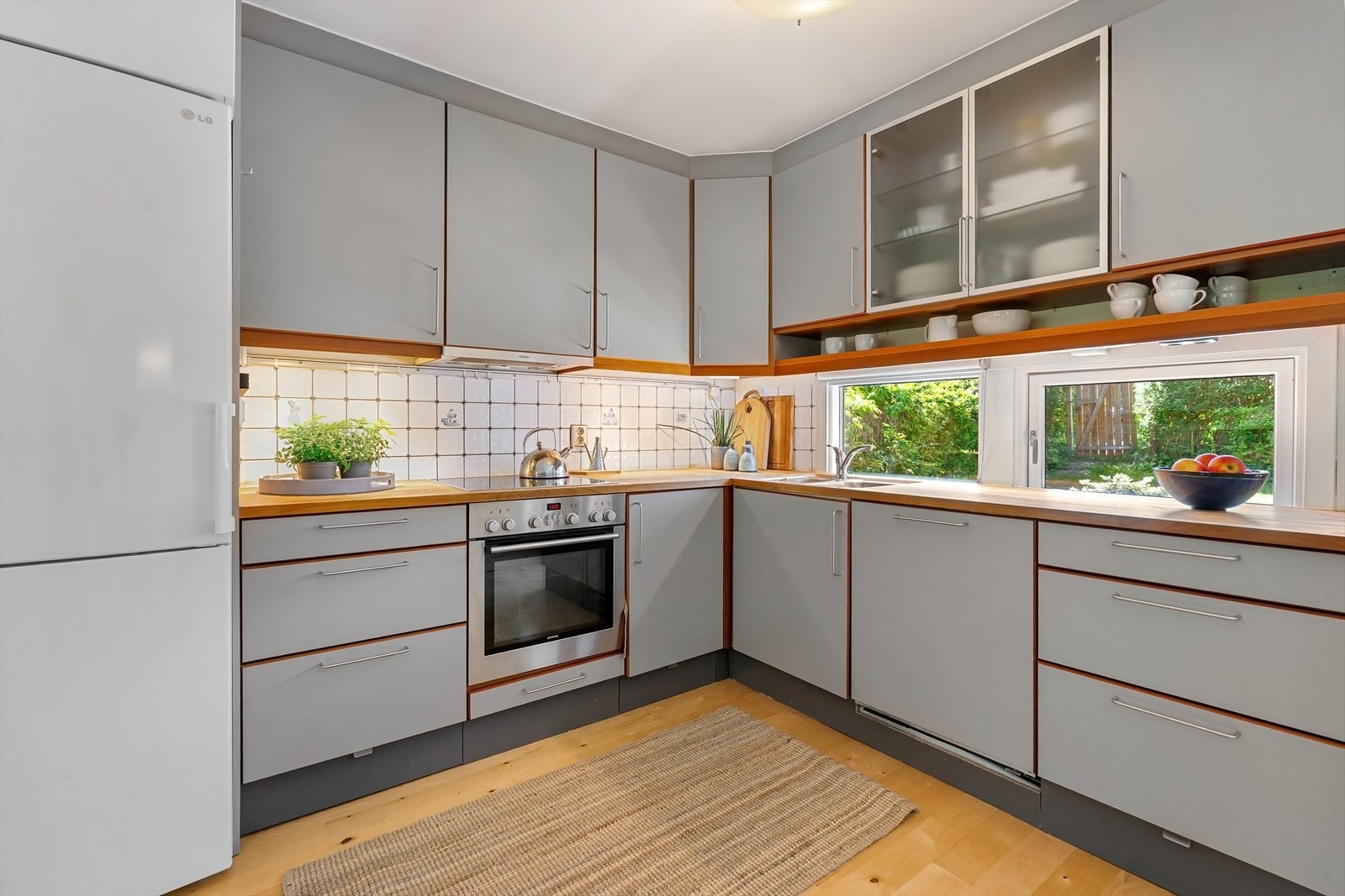 Velutstyrt kjøkken fra 2007 med glatte fronter med kirsebær listverk og heltre benkeplate. Kjøkkenventilator med avtrekk ut. Galleribilde