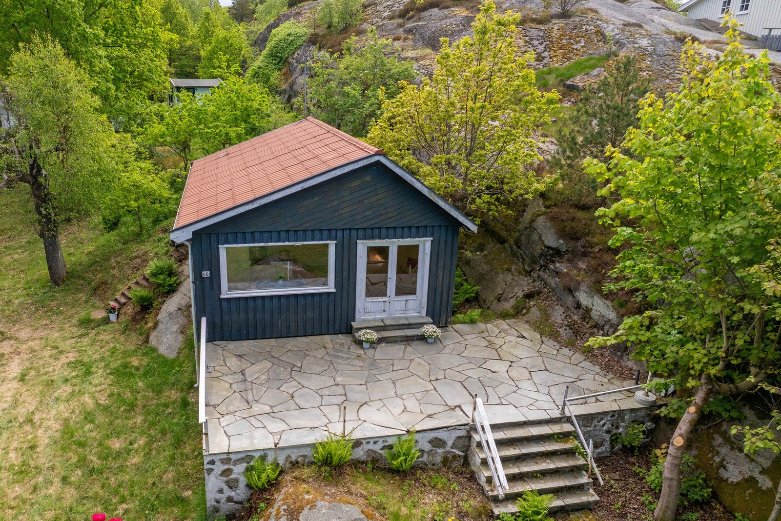 Eiendommen har en stor skiferlagt terrasse på ca. 38 m² med gode solforhold og fin plass til utemøbler, grill og hyggelige sommerdager. Uteplassen ligger skjermet til og danner en naturlig forlengelse av oppholdsrommene. Galleribilde