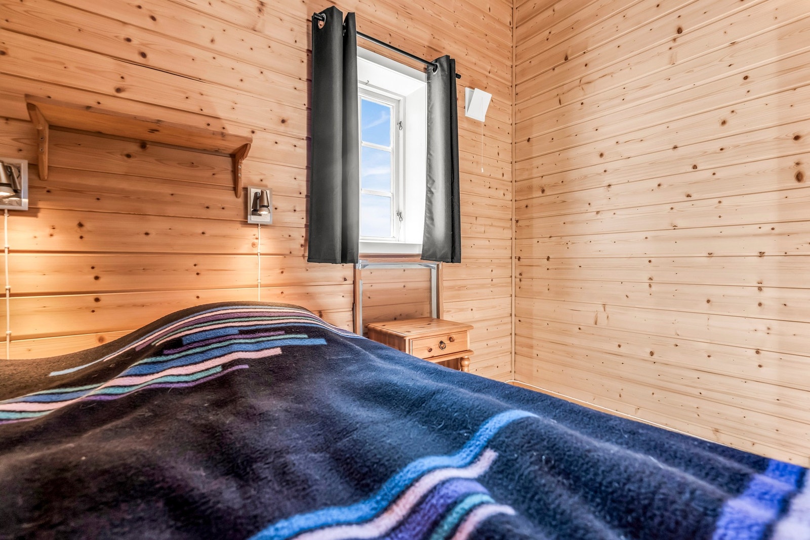 Soverom med panelvegger og vindu som slipper inn naturlig lys. Galleribilde