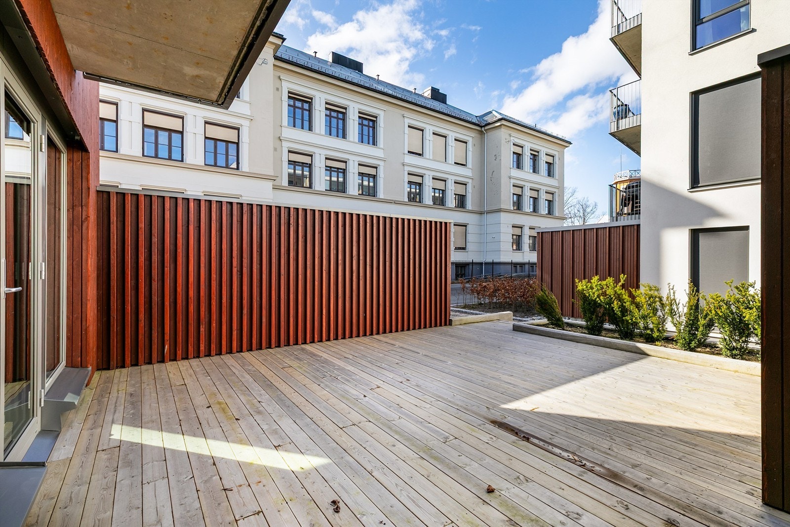 Terrassen er godt avskjermet med høye levegger på begge sider. Galleribilde
