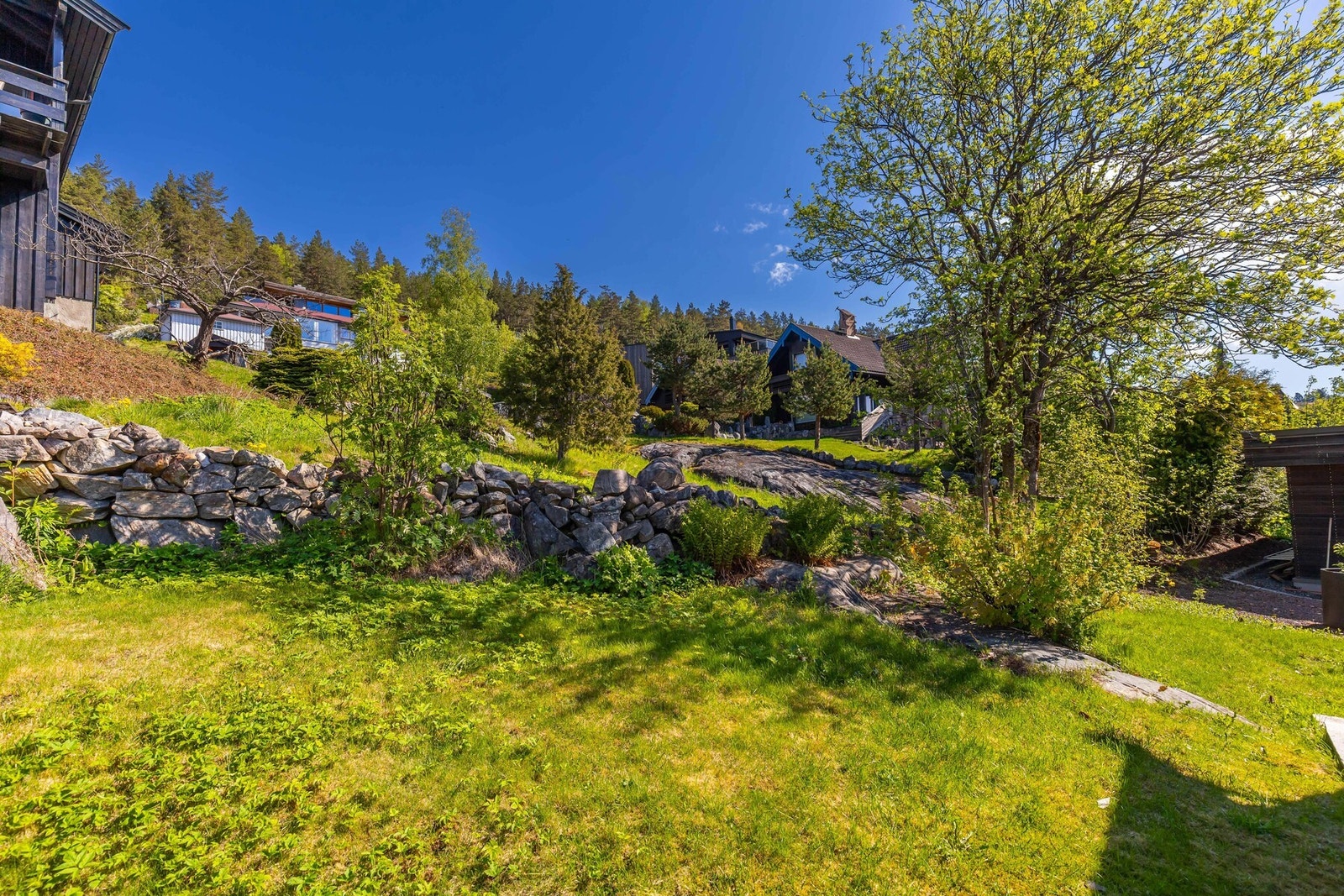 Hagen er pent opparbeidet med plenarealer, beplantning og natursteinsmurer som skaper et helhetlig og hyggelig uteområde. Galleribilde