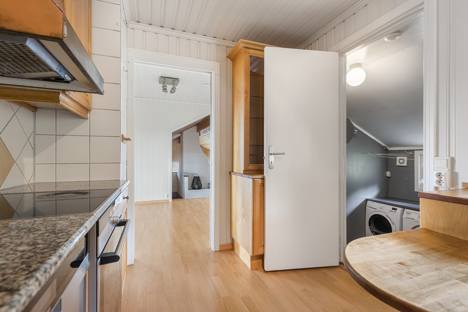 Kjøkkenet ligger i åpen forbindelse med spiseplass og oppholdsrom, noe som skaper en sosial og familievennlig løsning. Galleribilde