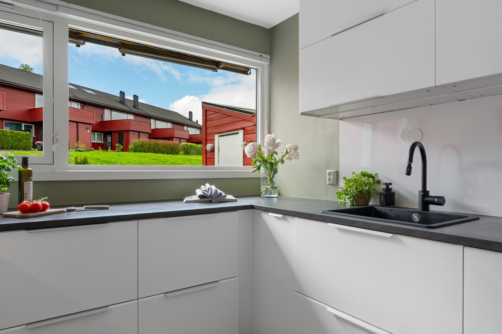 Kjøkkeninnredning med hvite glatte fronter og laminert benkeplate med kjøkken vask. Galleribilde