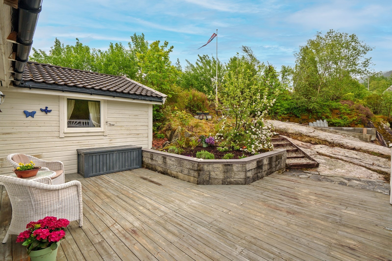 Tomten er pent opparbeidet med noe plen, beplantning og skiferlagte stier. For øvrig naturtomt med svaberg. Galleribilde