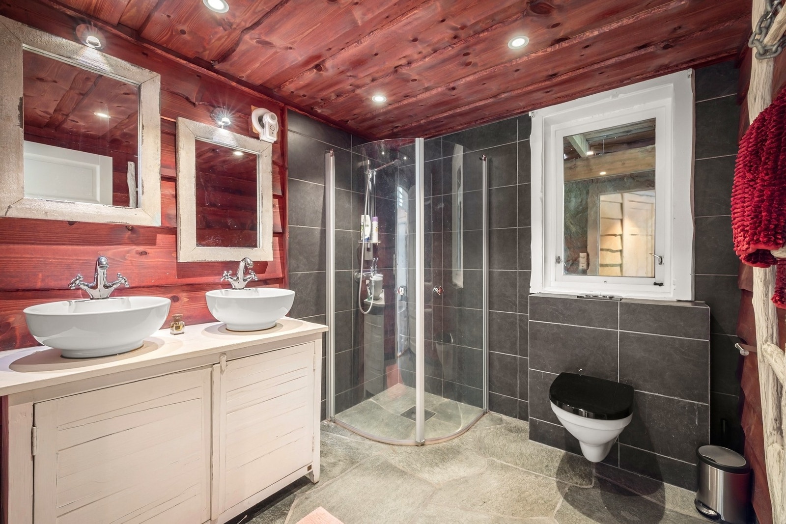 Badet ligger i hovedetasjen og har flislagte overflater i dusjsonen, villmarkspanel på øvrige vegger/tak og varmekabler i gulv. Galleribilde