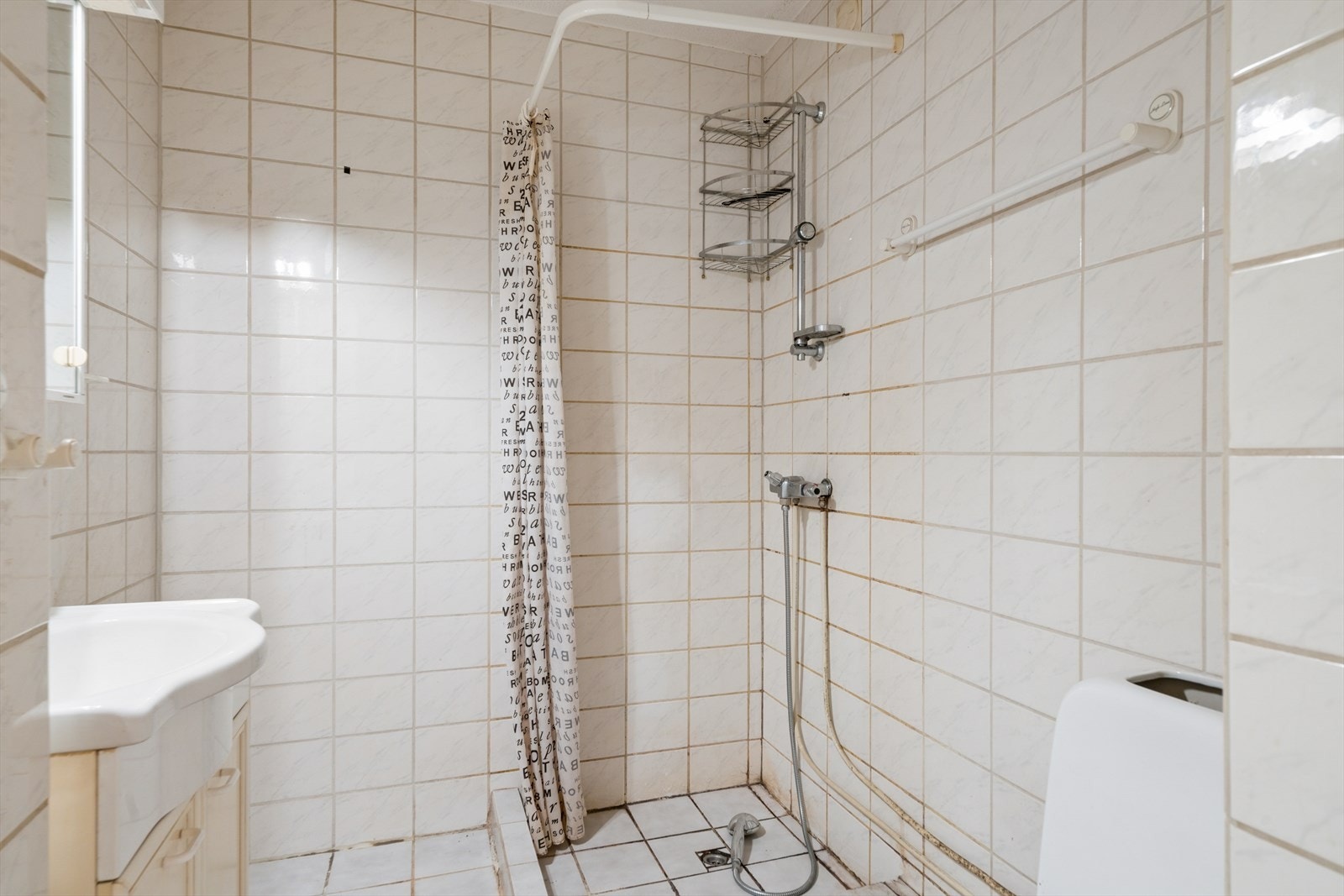 Bad med WC, dusjplass og servant med ettgreps blandebatteri i innredning. Galleribilde