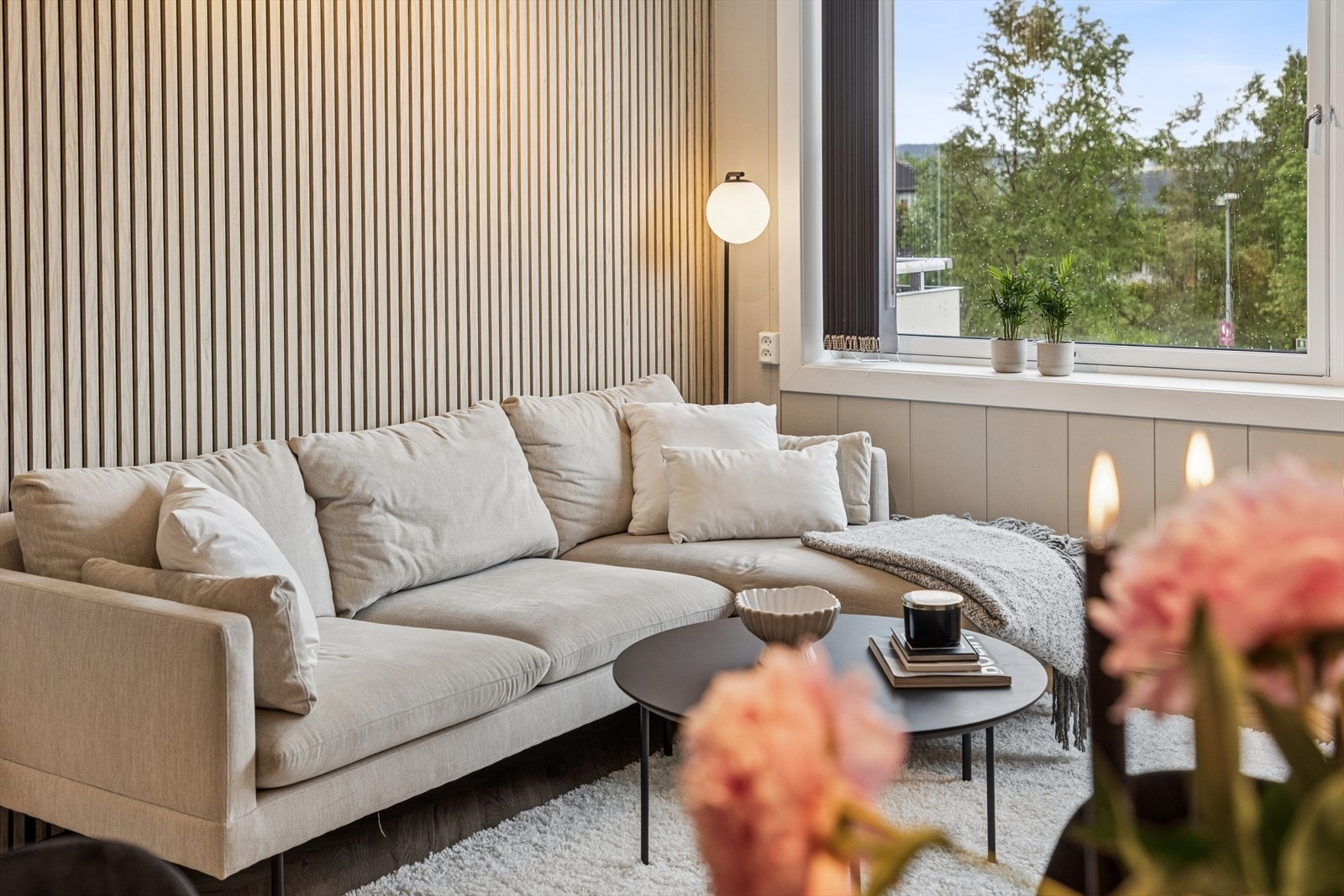 Beige veggtoner, spilevegg som dekorativ kontrast og elegant fiskebeinsparkett skaper en lun og stilren atmosfære. Galleribilde