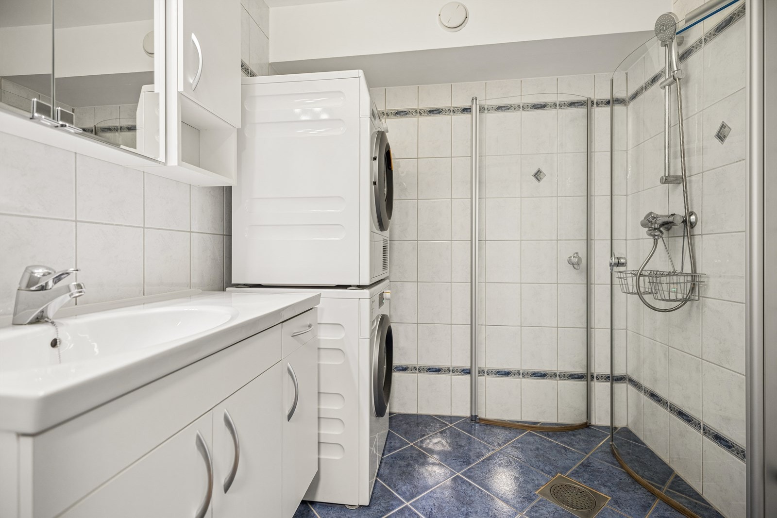 Badet er innredet med praktisk dusjhjørne og har god plass til vaskemaskin og tørketrommel Galleribilde