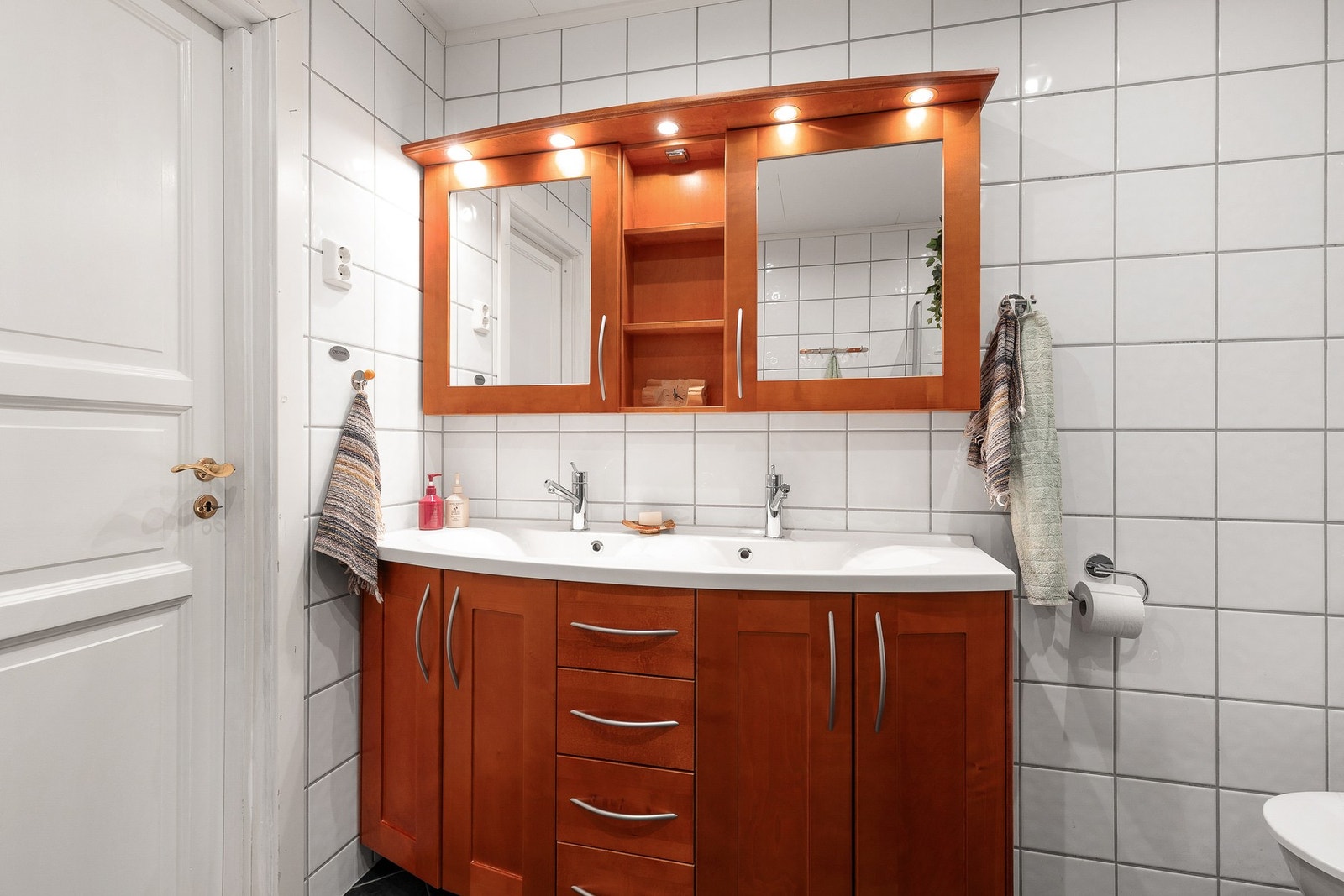 Badet har innredning med to nedfelte servanter, gulvstående toalett og dusjhjørne Galleribilde