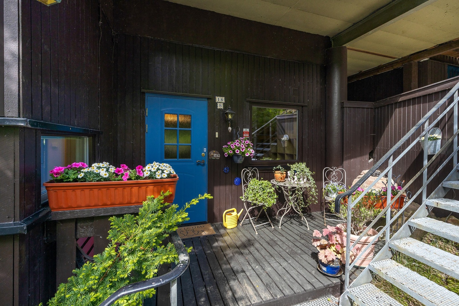 Inngangsparti er takoverbygd med terrassebord på gulv Galleribilde