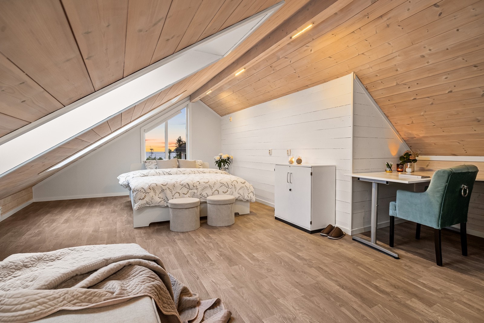 Stor, innredet hems i andre etasje med panel på vegger og i tak. Galleribilde