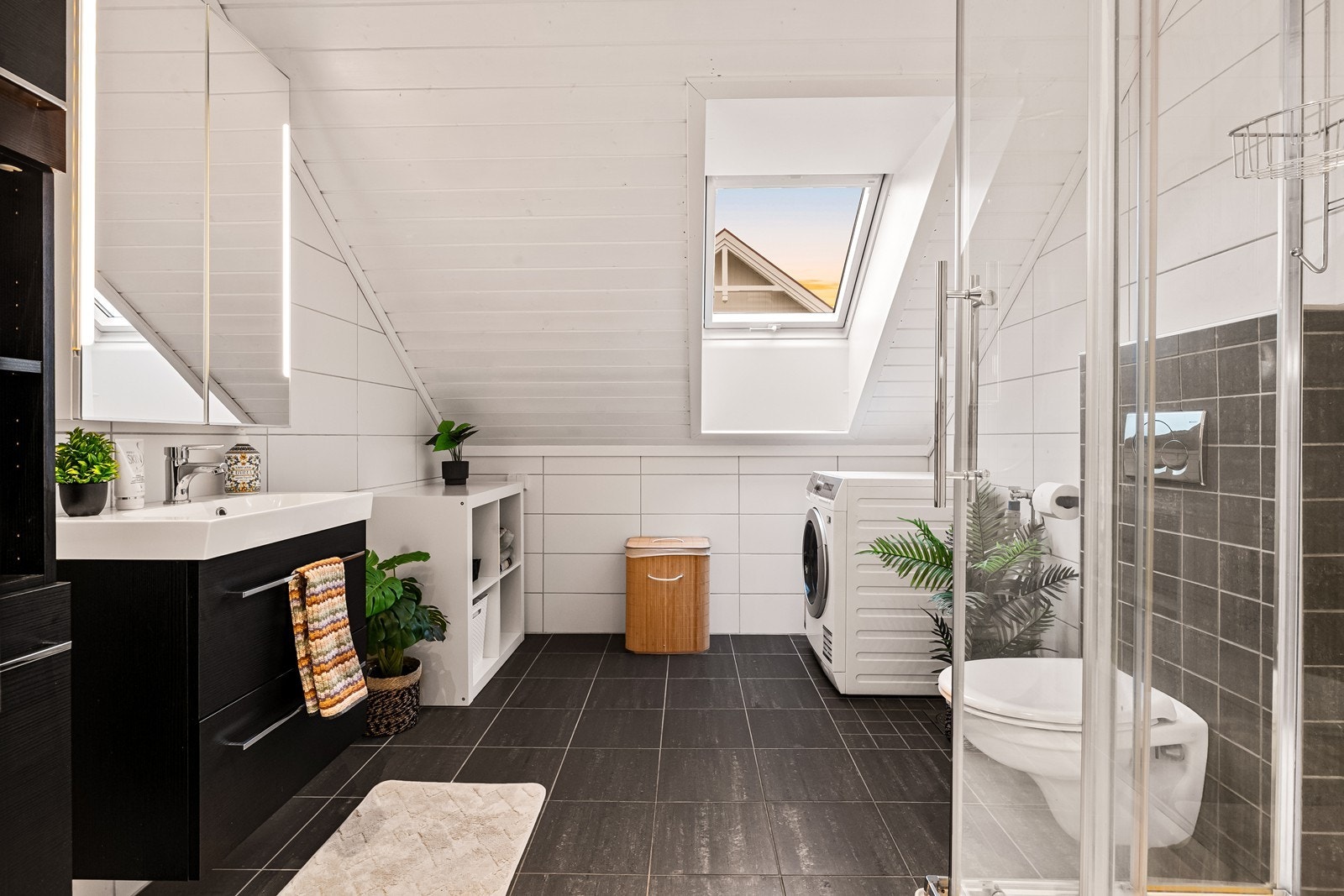 Badet i andre etasje har flislagt gulv med vannbåren varme, dusjkabinett og opplegg for vaskemaskin. Galleribilde