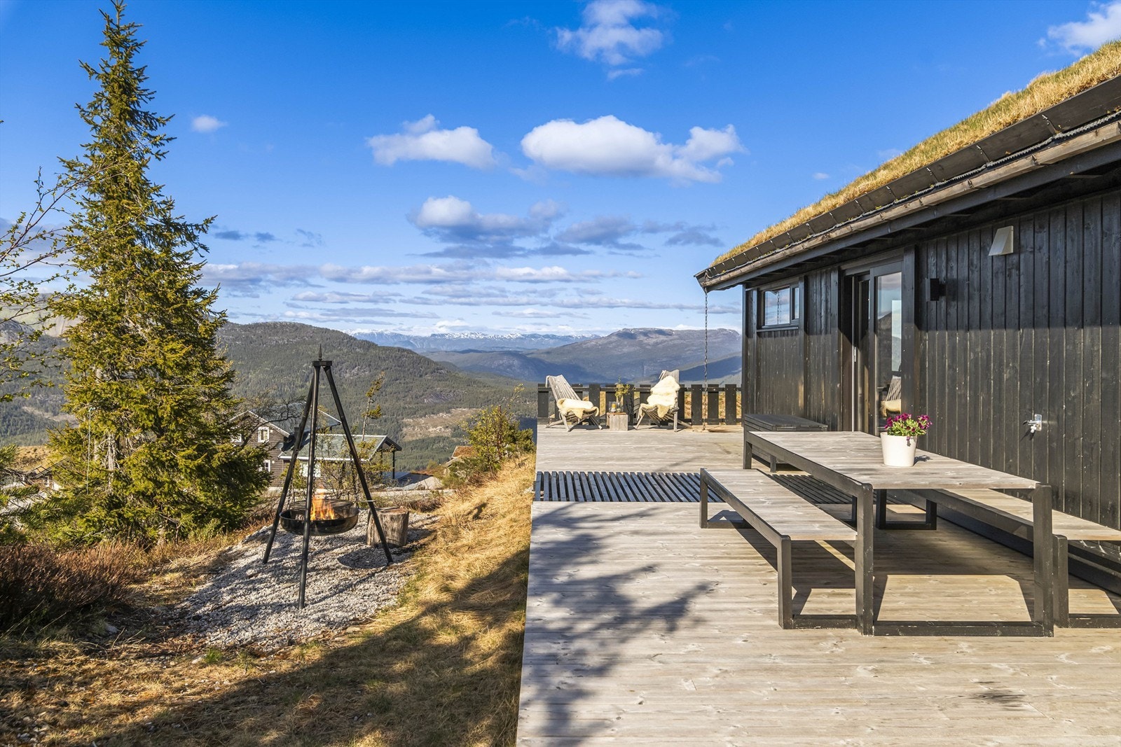 Den store terrassen på 136 m² omkranser hytta og har flere soner, inkludert en egen bålpanne for stemningsfulle kvelder. Galleribilde