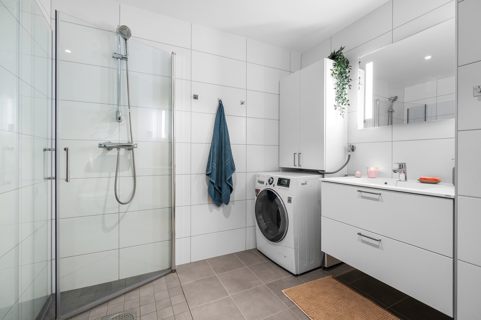 Pent flislagt baderom på 5,5m². Her får du flott servant med underskap, dusjhjørne, vegghengt WC og opplegg for vaskemaskin Galleribilde