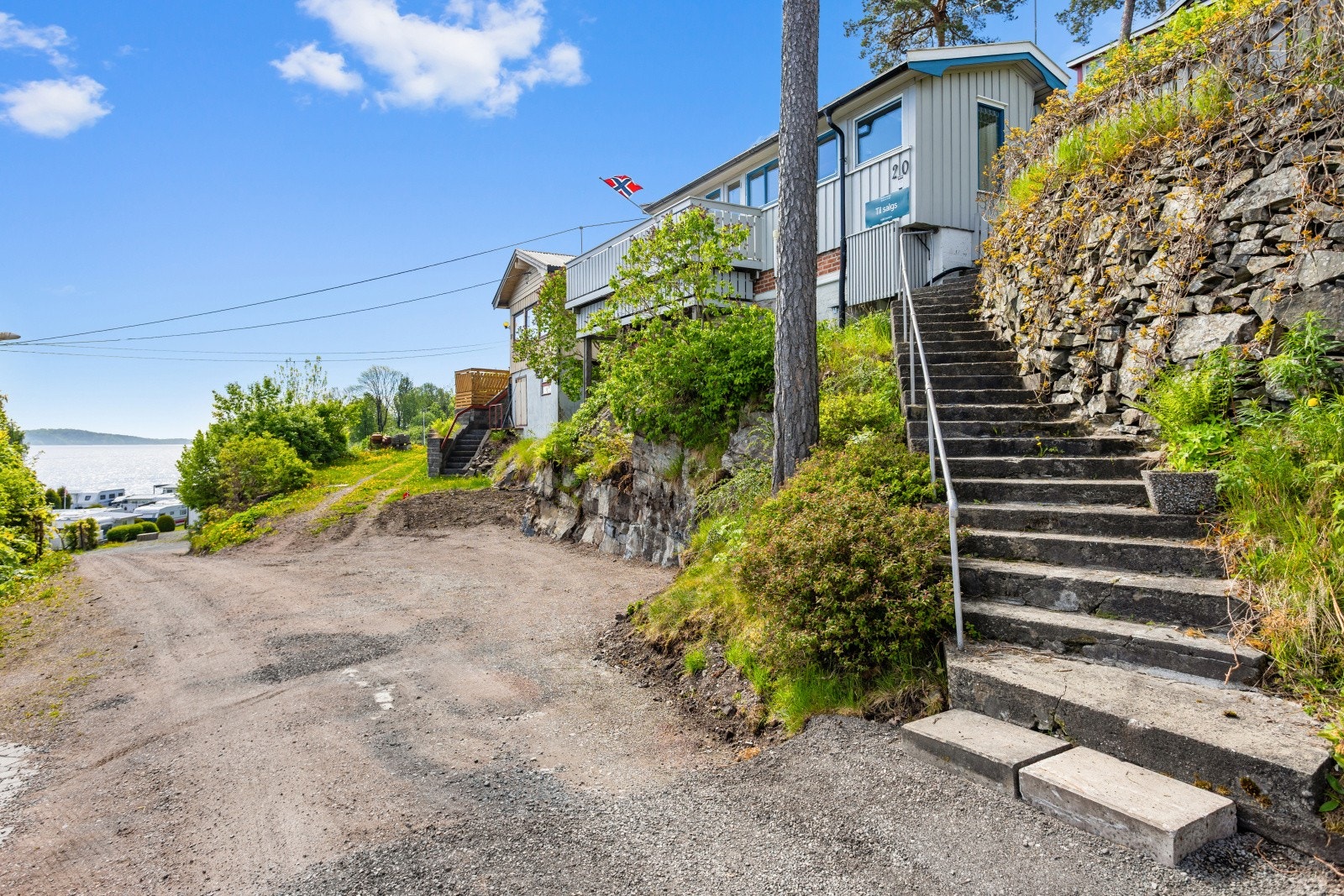Adkomst til eiendommen via en betongtrapp fra parkeringsområdet. Her har du også plass til å parkere på tomten. Galleribilde