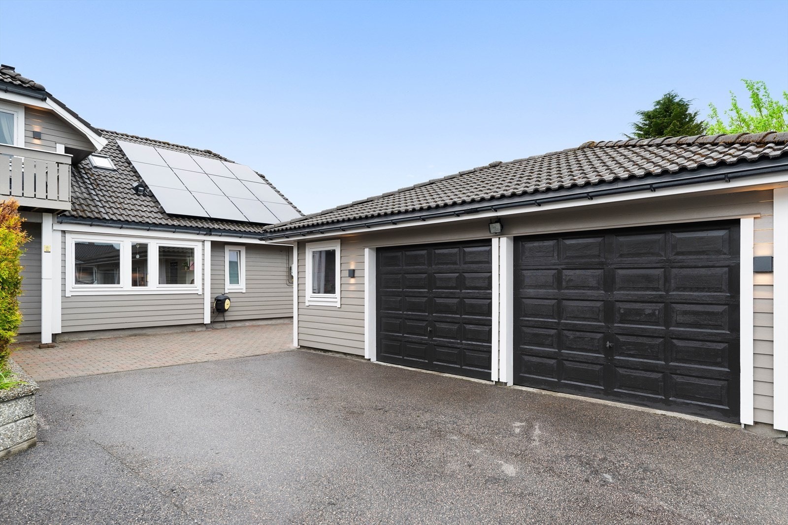 Dobbelgarasje med elbil-lader. Solcellepanel på hustak. Galleribilde