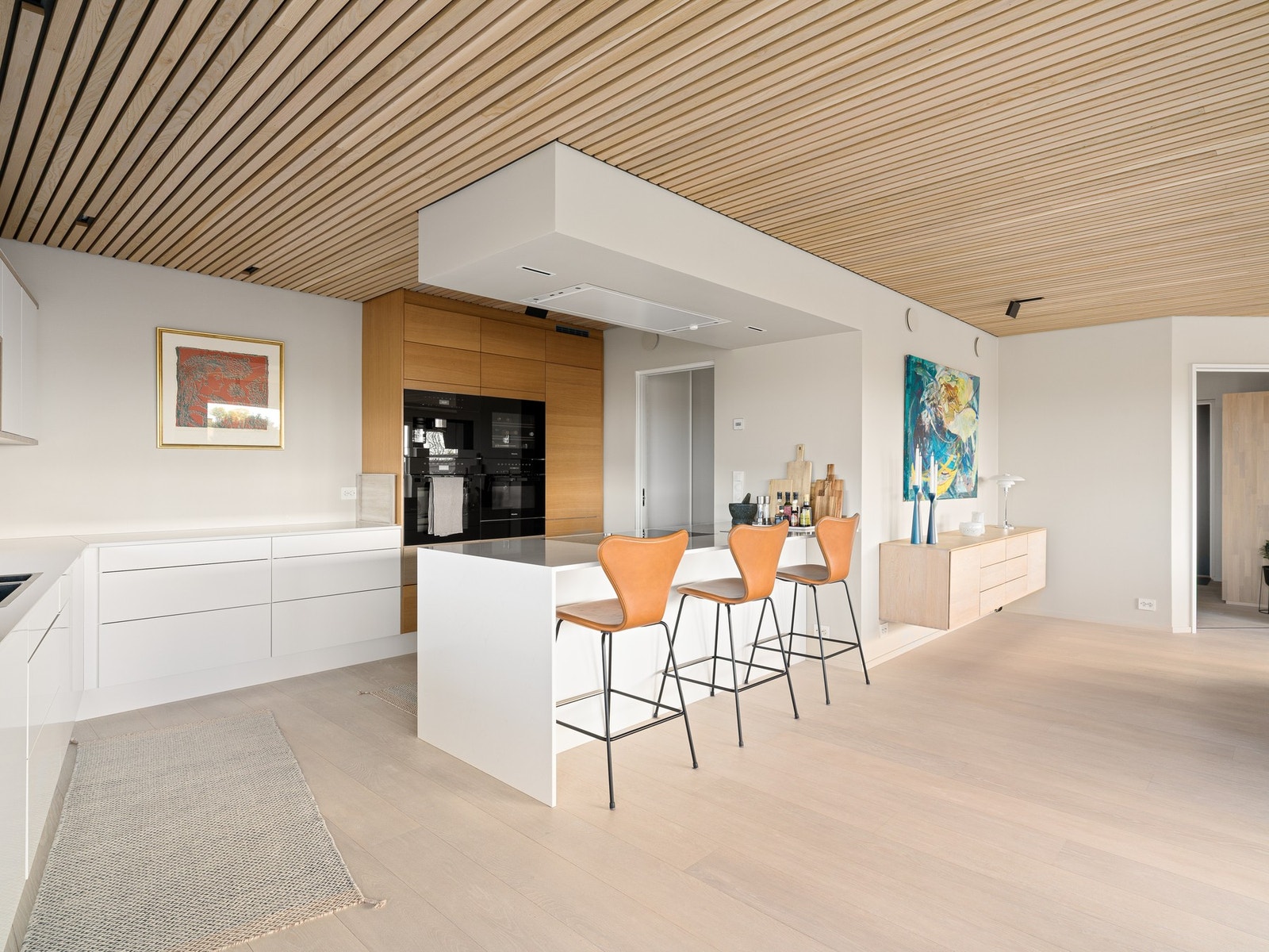 Innredningen er utført i en elegant kombinasjon av heltre eik og laminerte, slette fronter, som tilfører varme samtidig som designet oppleves minimalistisk og gjennomført. Galleribilde