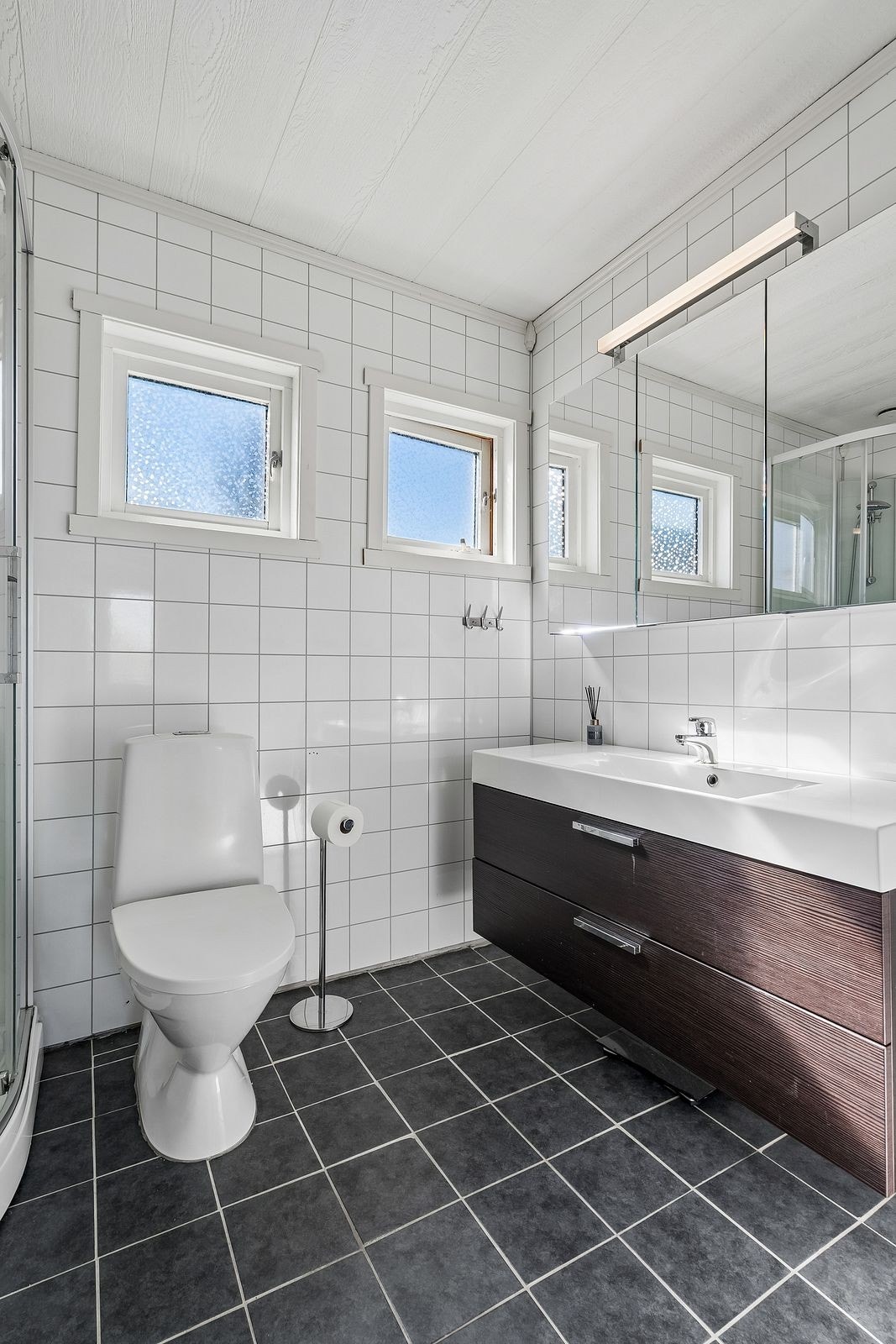 Moderne bad med dusjkabinett og heldekkende servant, samt naturlig ventilasjon. Galleribilde