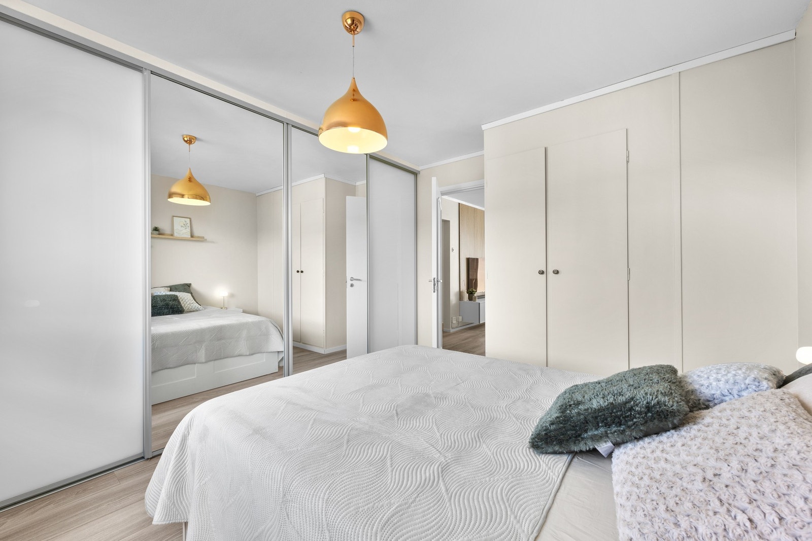 Rommet er lyst og fint, har laminatgulv og en stor skyvedørsgarderobe med speil og masse oppbevaringsplass. Galleribilde