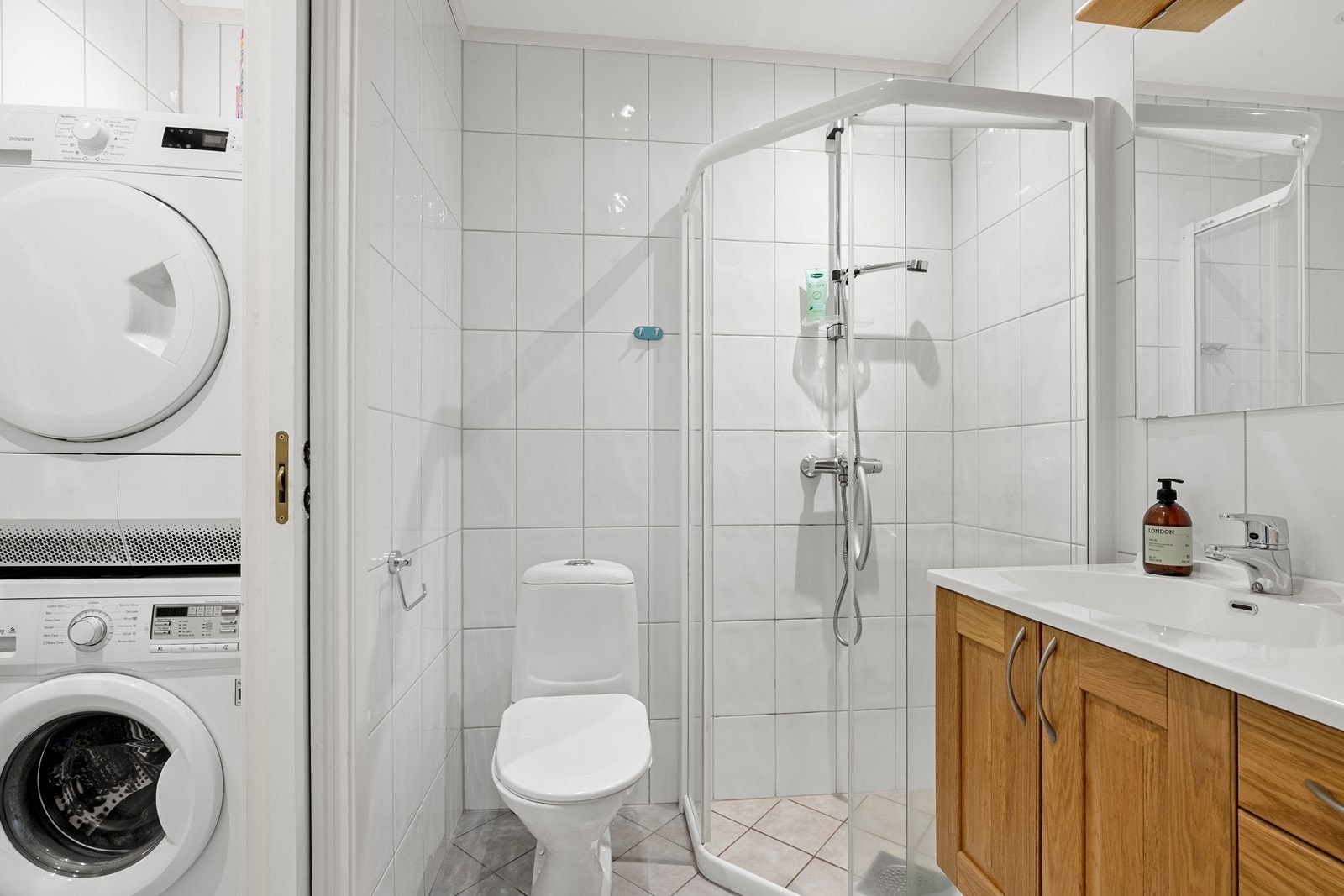 Badet er flislagt, har gulvvarme for komfort og er utstyrt med dusjhjørne med glassdører. Galleribilde