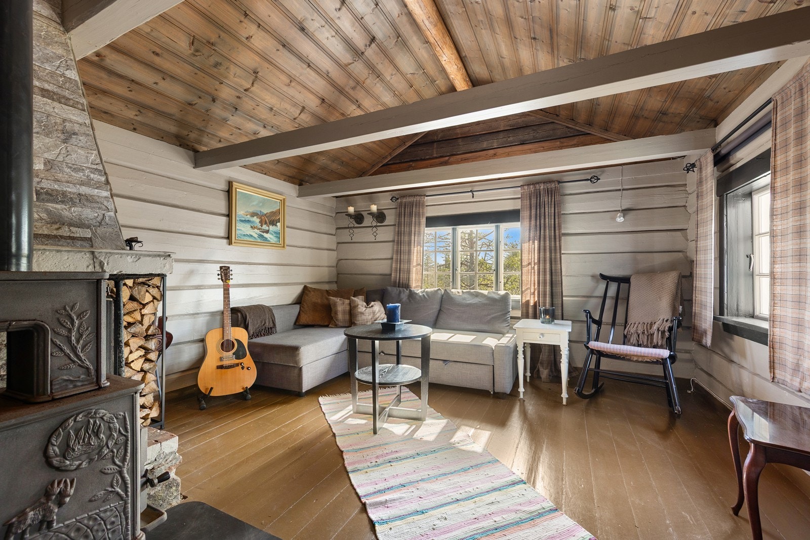 Stuen er et lunt samlingspunkt med en åpen peis i murstein. Galleribilde