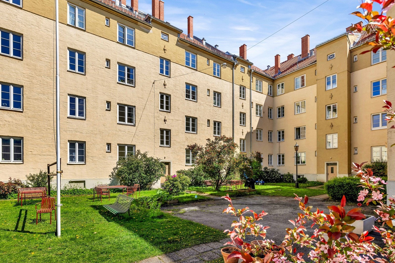 Stor og skjermet bakgård med sittegrupper, lekeplass og grillmuligheter. Galleribilde