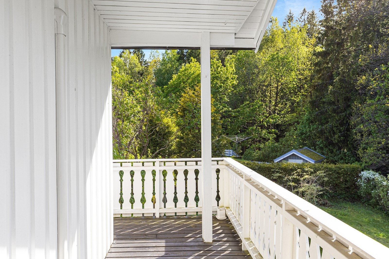 Huset har en veranda som omkranser 2 sider av fasaden. Galleribilde