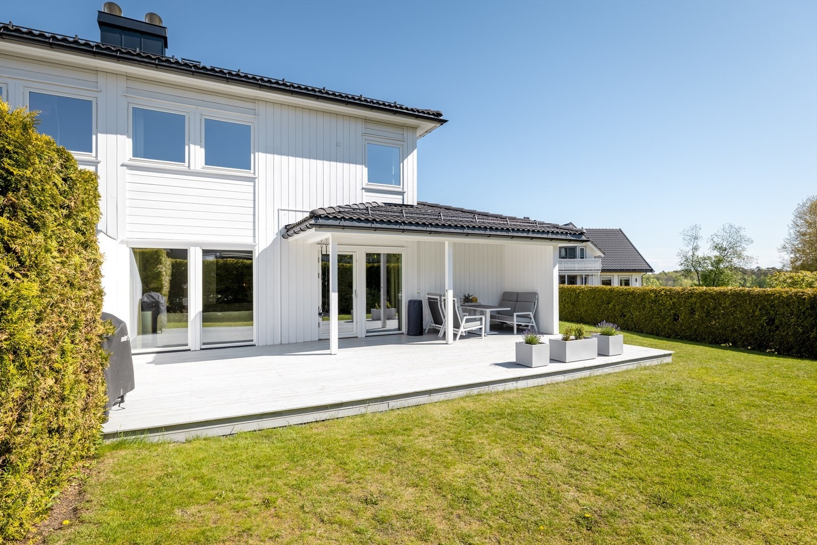 Omtrent 10 m² av terrassen er overbygget, noe som gir en lun og skjermet uteplass for kjøligere kvelder. Galleribilde