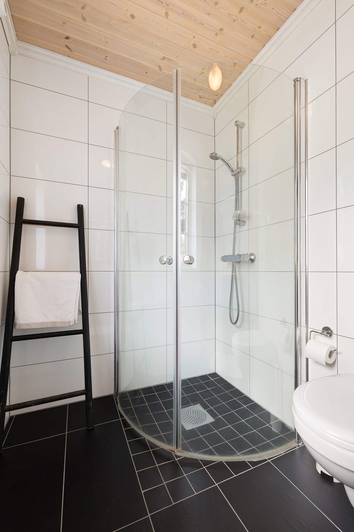 Gulvet er utstyrt med varmekabler, og rommet har mekanisk avtrekk via elektrisk vifte. Badet er innredet med vegghengt toalett, servant og dusjnisje. Galleribilde