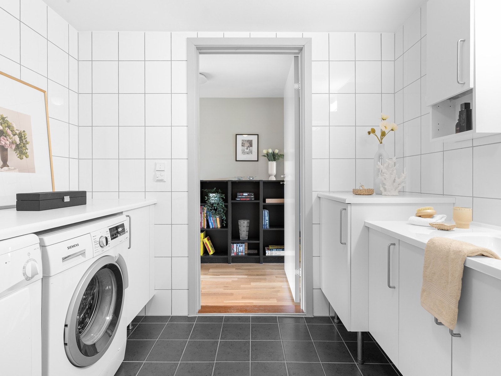 Rommet er innredet med servantskap med gode oppbevaringsmuligheter, toalett og dusjhjørne. Det er i tillegg opplegg for vaskemaskin, samt plass til tørketrommel i praktisk innredning med benkeplate. Galleribilde