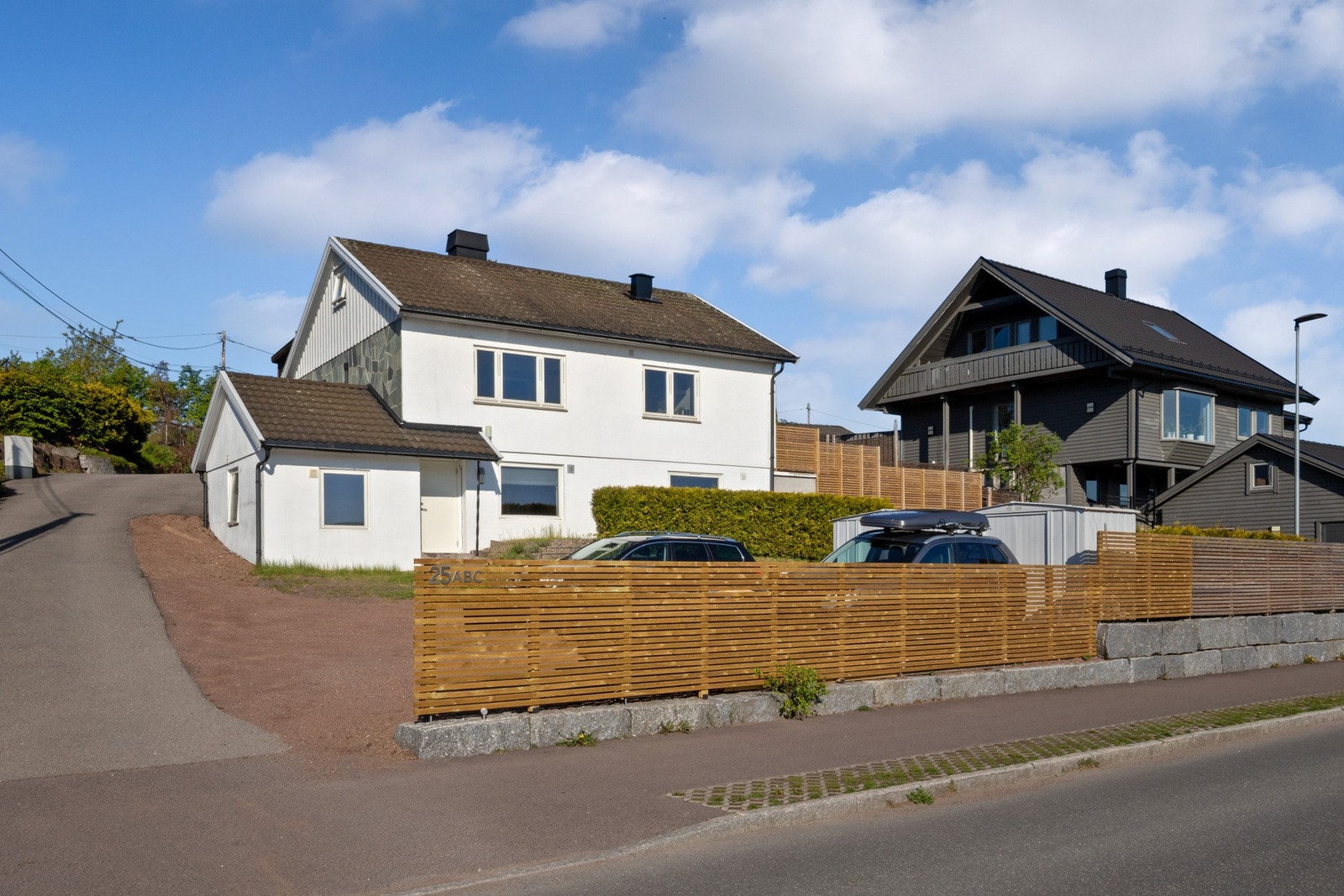 Hvit enebolig med nyoppført terrasse og opparbeidet uteområde Galleribilde