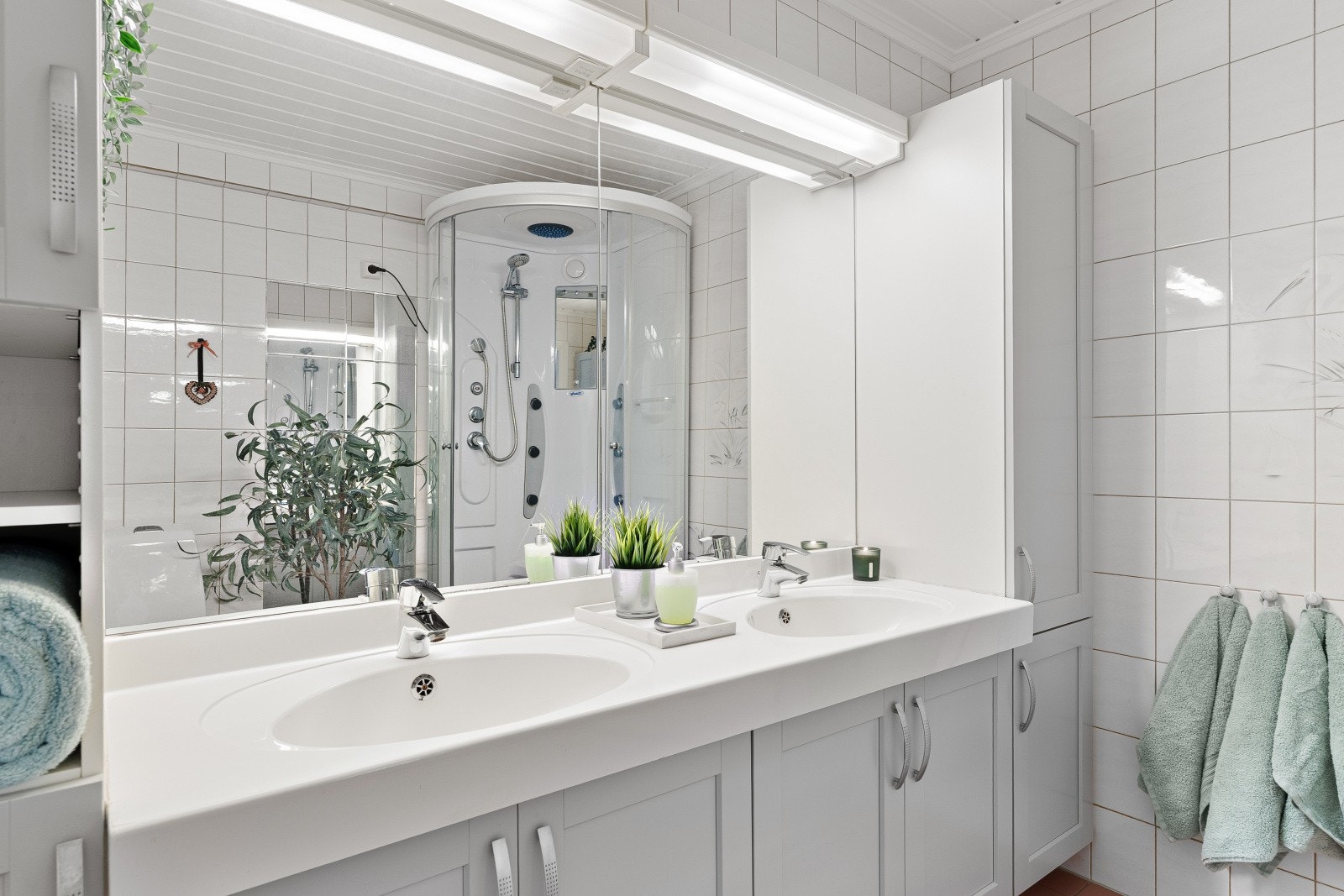 Badet er utstyrt med dobbeltservant, toalett og dusjkabinett. Galleribilde