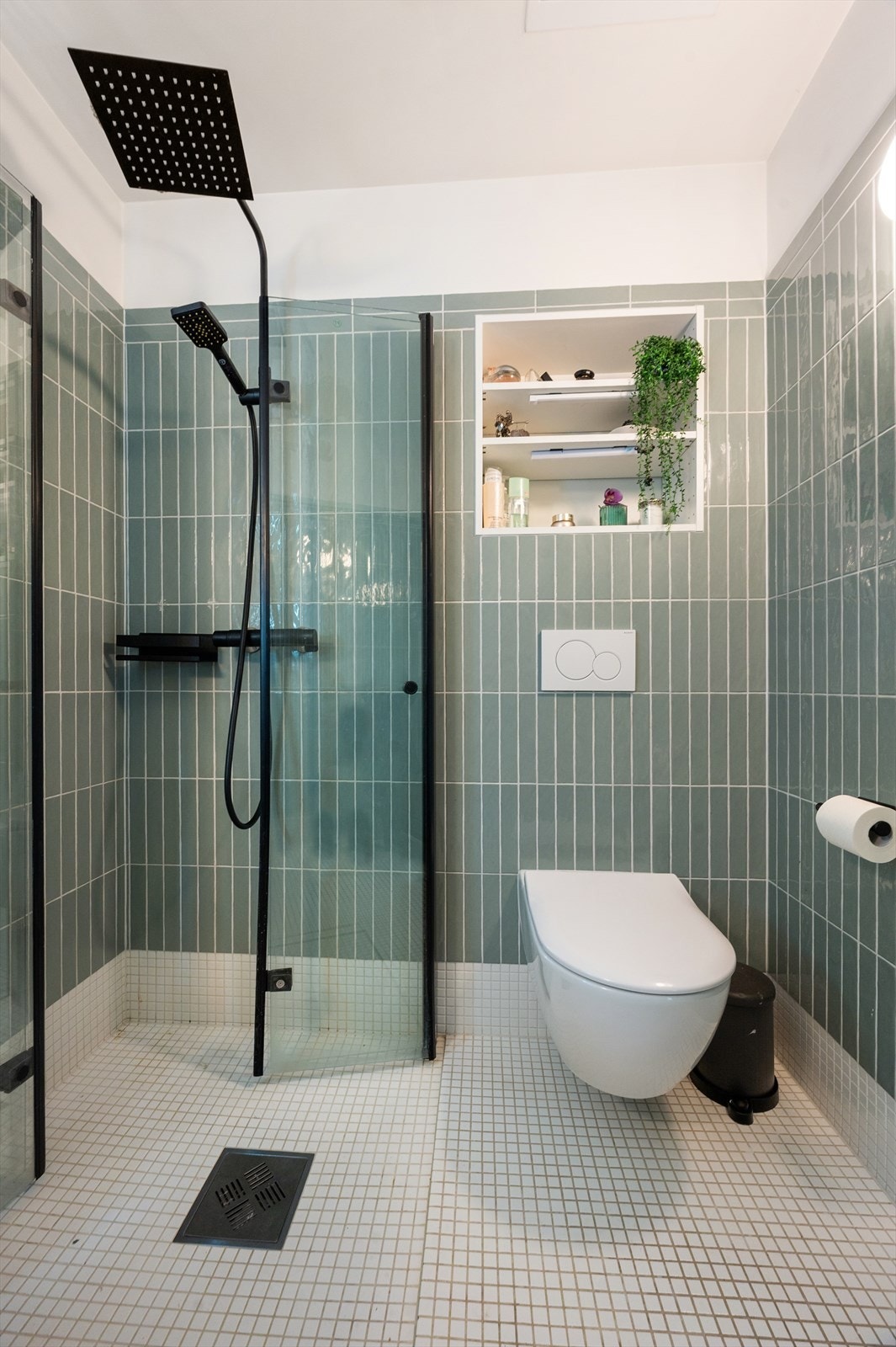 Badet er innredet med vegghengt toalett og egen dusjsone med innfellbare glassdører. Galleribilde