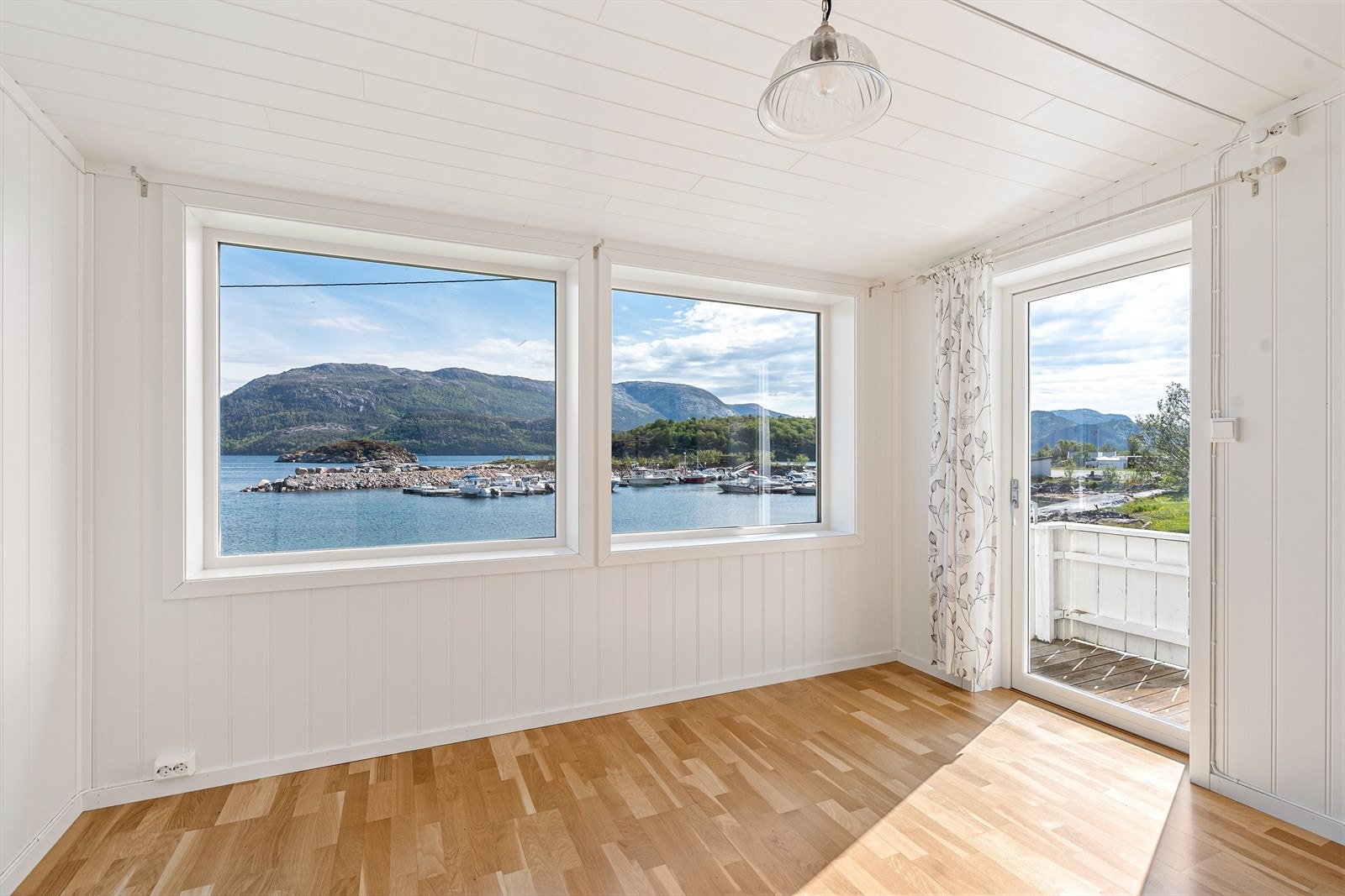 Fra den lyse og innbydende stuen som ligger i tilbygget fra 2014, er det utgang til hagen og den store eiendommen via trapp. Galleribilde
