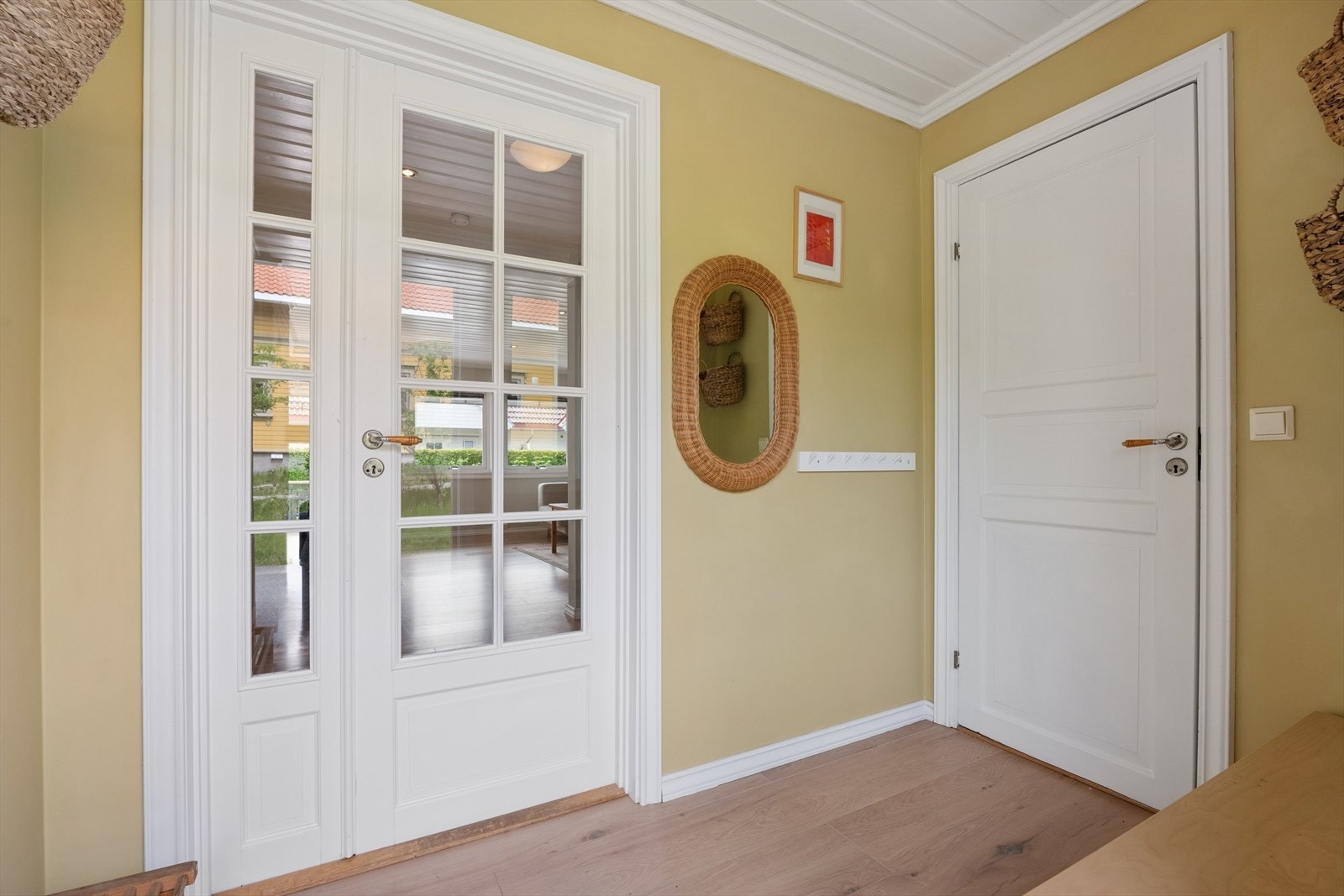 Entré med doble glassdører som slipper lyset inn og leder videre til stuen. Galleribilde