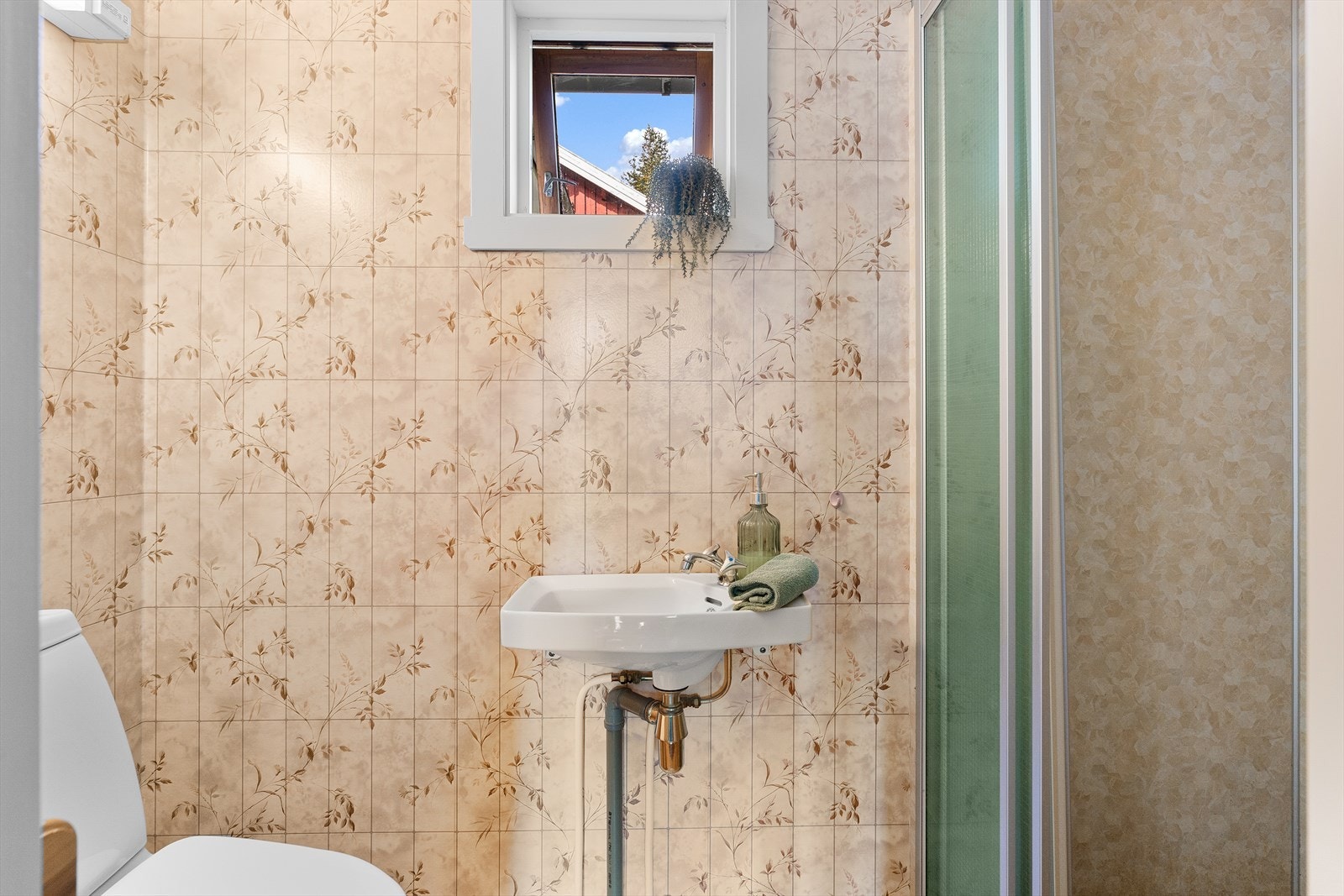 Badet er eldre og inneholder et toalett, enkel vask, samt en dusjnisje. Galleribilde