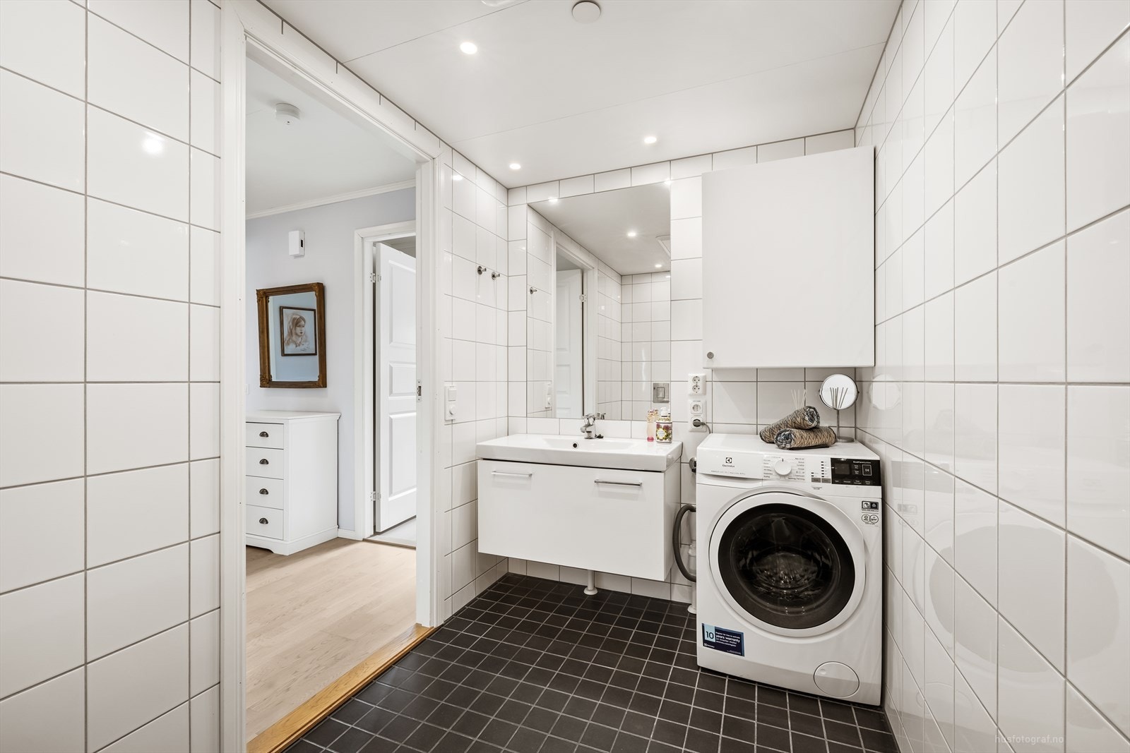 Badet har servant med underskap og opplegg for vaskemaskin. Galleribilde
