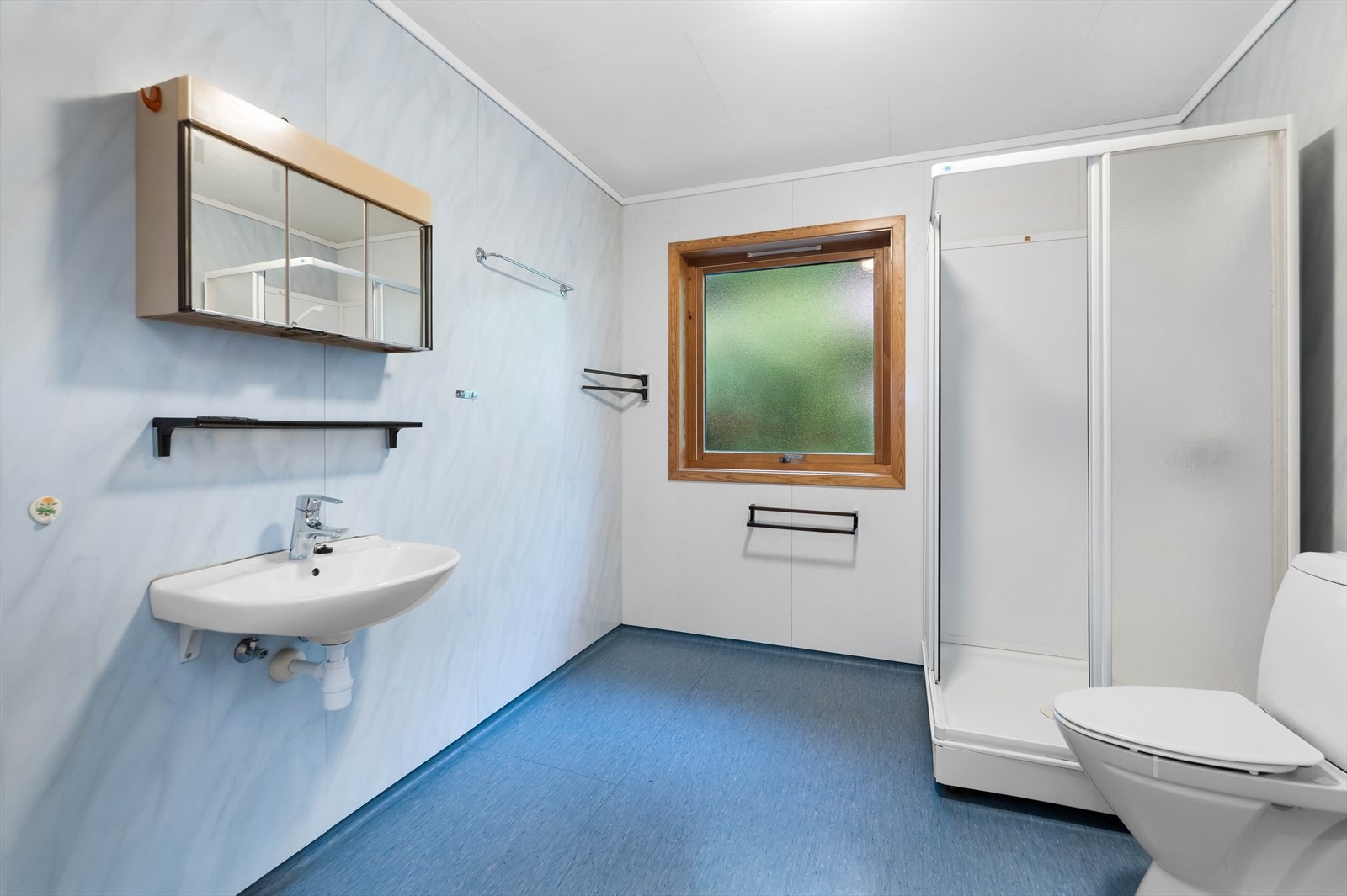 Badet har vinylbelegg på gulv og baderomsplater på veggene. Galleribilde