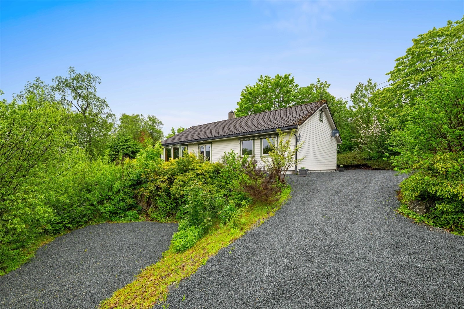 Landlig beliggenhet med parkering på egen, gruset tomt. Nærbutikk og bussholdeplass ligger kun få hundre meter unna. Galleribilde