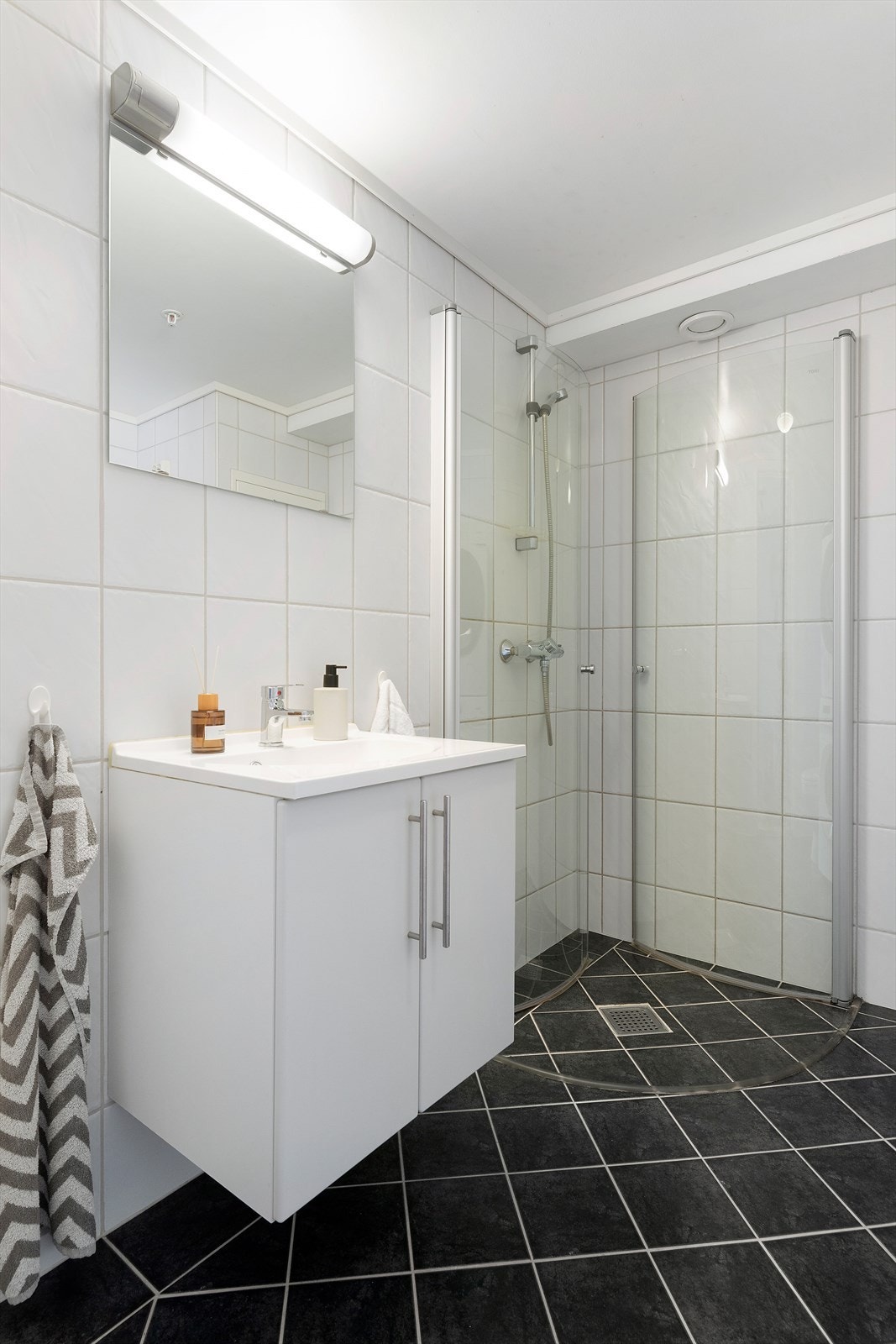 Innredet med servantskap, wc, dusjnisje i hjørnet, opplegg for vaskemaskin og tørketrommel. Galleribilde