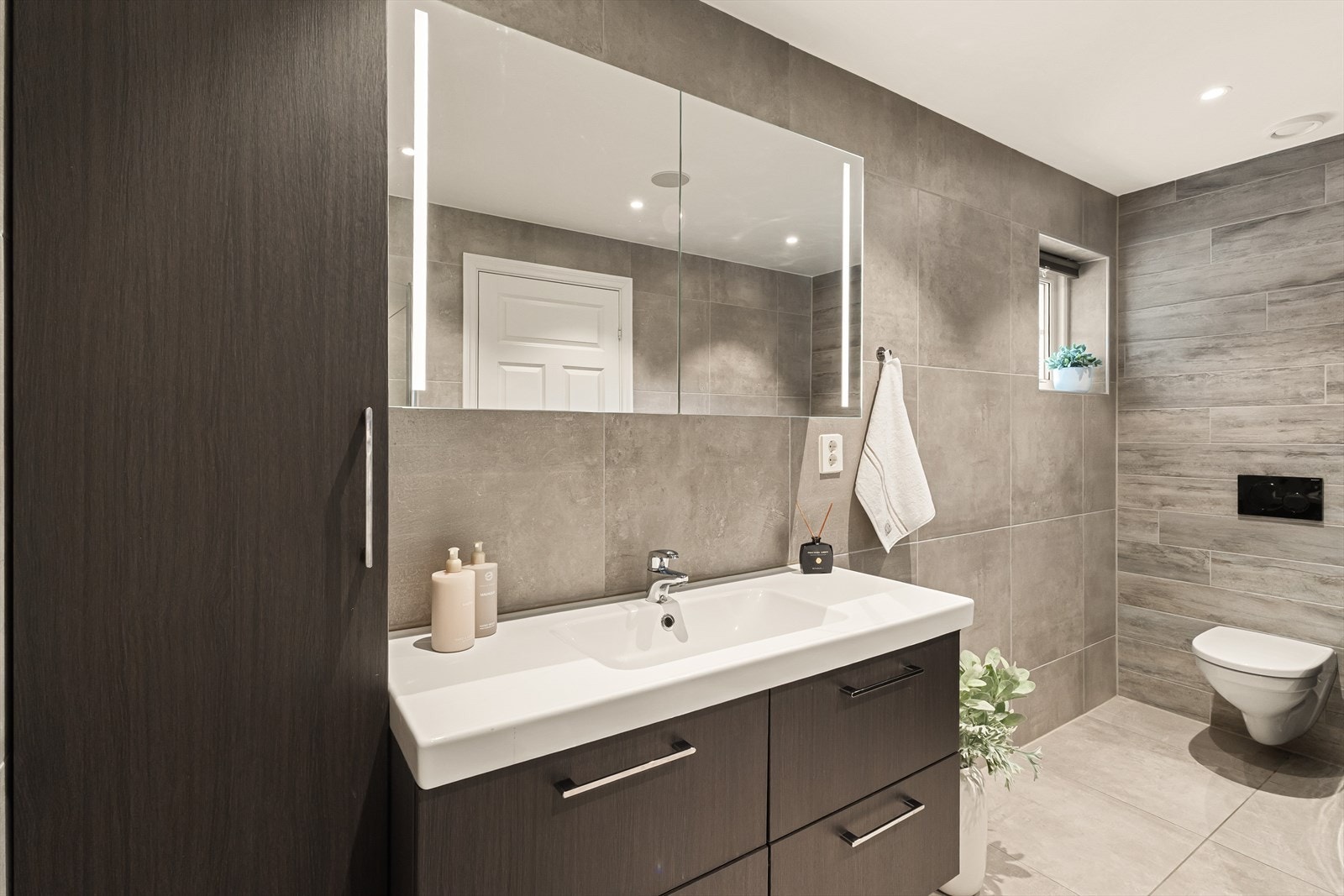 Badet er helfliset og pent med moderne fargevalg og innredning. Galleribilde